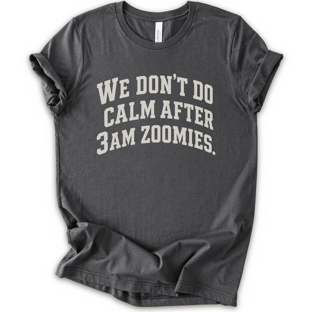 An asphalt short-sleeve crewneck t-shirt with the text 'WE DON'T DO CALM AFTER 3AM ZOOMIES.' printed in a distressed white font on the front.