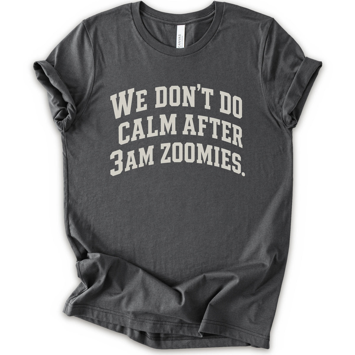 An asphalt short-sleeve crewneck t-shirt with the text 'WE DON'T DO CALM AFTER 3AM ZOOMIES.' printed in a distressed white font on the front.