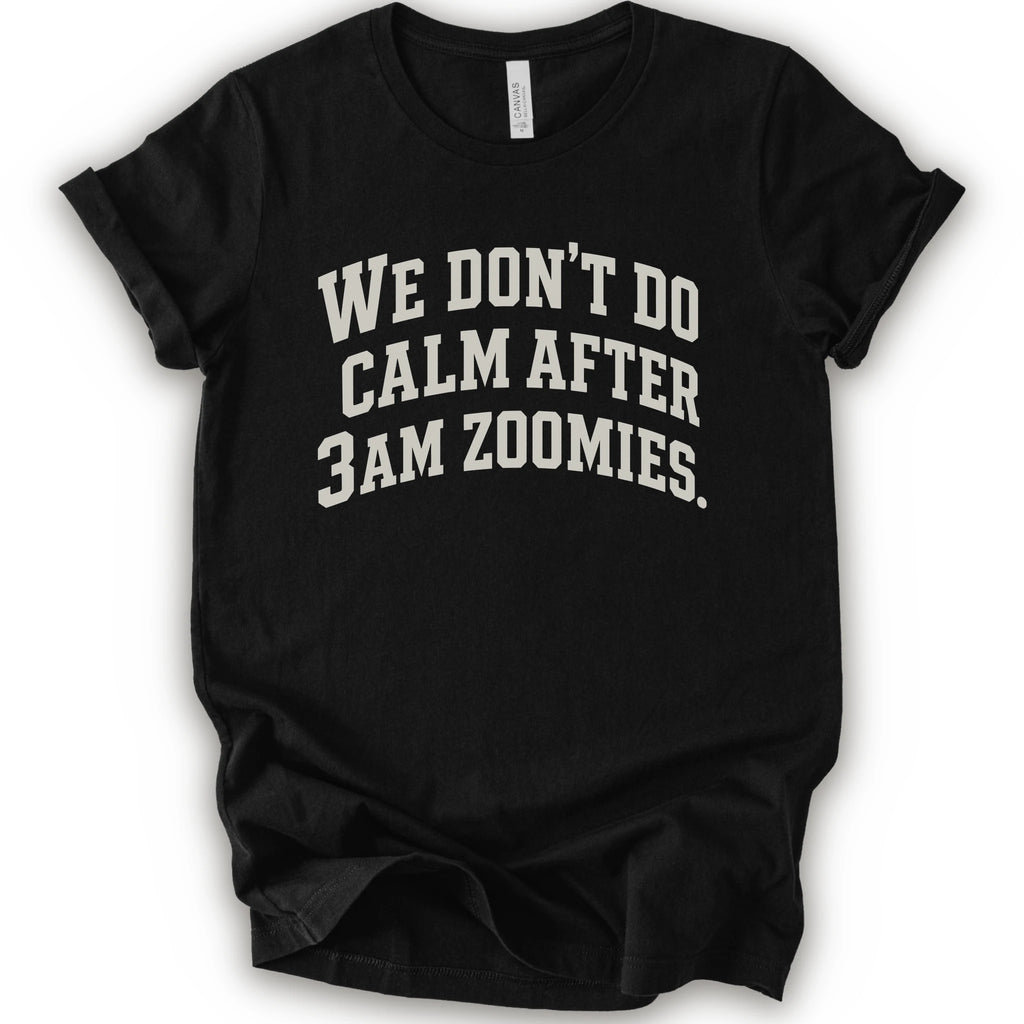 A black short-sleeve crewneck t-shirt with the text 'WE DON'T DO CALM AFTER 3AM ZOOMIES.' printed in a distressed white font on the front.