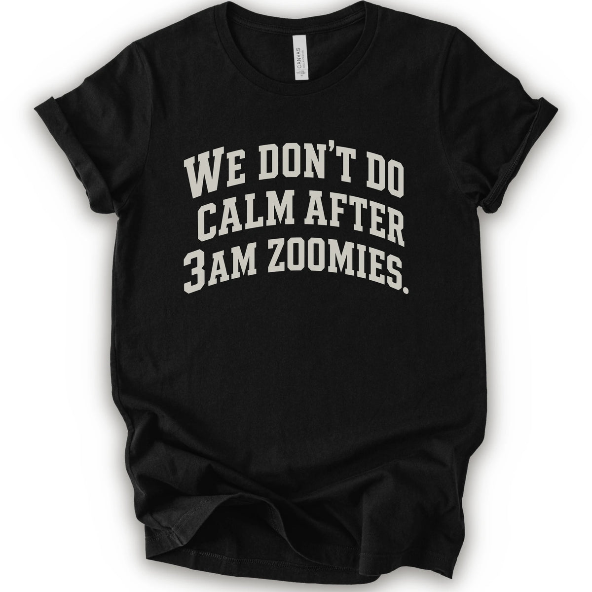 A black short-sleeve crewneck t-shirt with the text 'WE DON'T DO CALM AFTER 3AM ZOOMIES.' printed in a distressed white font on the front.