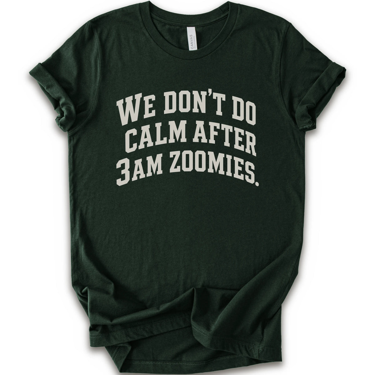 A forest short-sleeve crewneck t-shirt with the text 'WE DON'T DO CALM AFTER 3AM ZOOMIES.' printed in a distressed white font on the front.