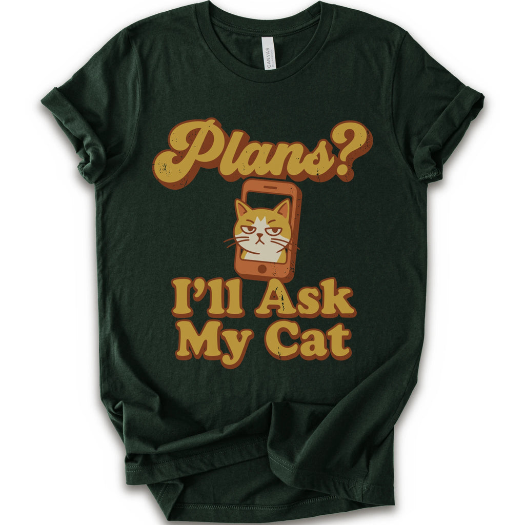 A forest crewneck t-shirt with a graphic print that reads 'Plans? I'll Ask My Cat' in a retro yellow-orange font, featuring a grumpy orange tabby cat cartoon inside a smartphone.