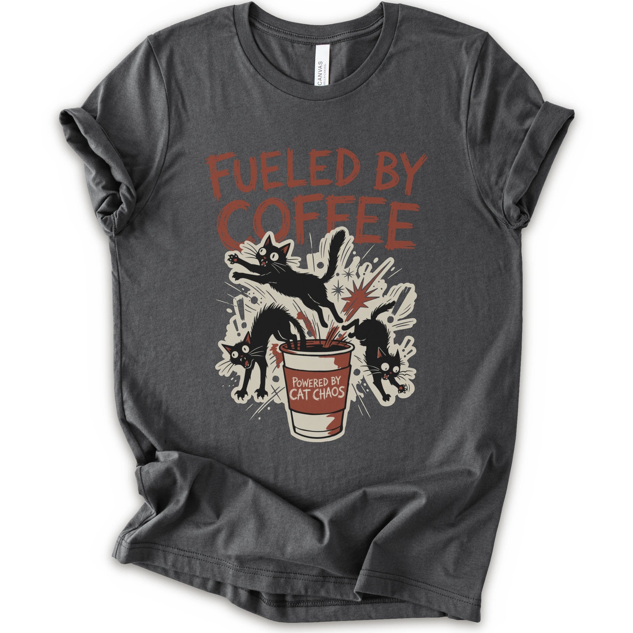 A asphalt short-sleeve graphic t-shirt laid flat on a white background. The shirt features a distressed graphic print with the text 'FUELED BY COFFEE' in a reddish-brown color, above an illustration of black cats emerging from a coffee cup labeled 'POWERED BY CAT CHAOS'.
