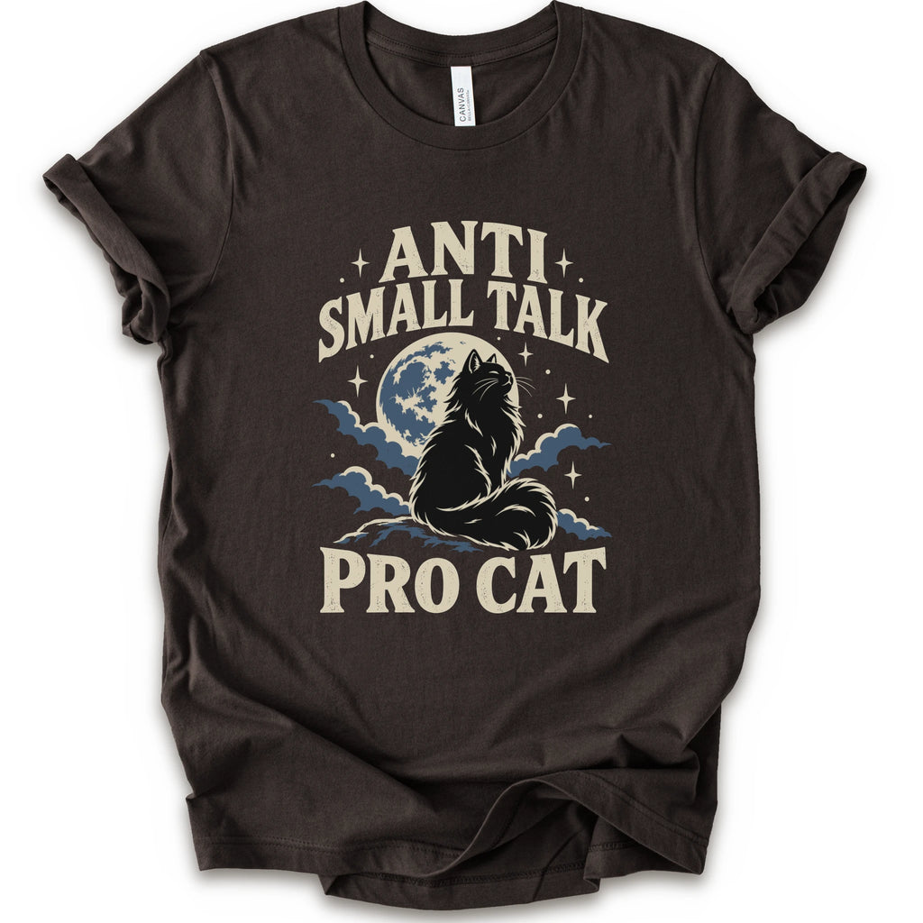 A brown short-sleeve t-shirt with a graphic print featuring a cat silhouette in front of a full moon and clouds, with the text 'ANTI SMALL TALK PRO CAT' in a cream-colored font.