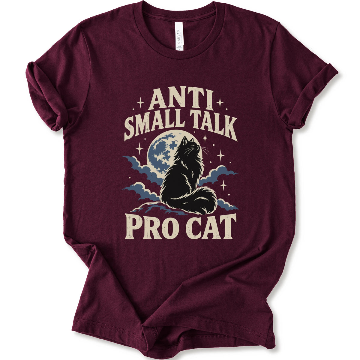 A maroon short-sleeve t-shirt with a graphic print featuring a cat silhouette in front of a full moon and clouds, with the text 'ANTI SMALL TALK PRO CAT' in a cream-colored font.