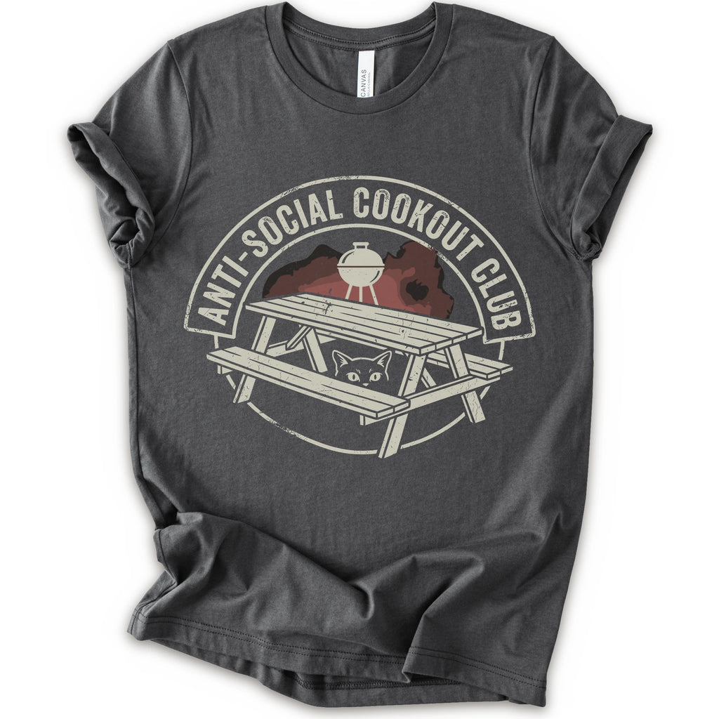 A asphalt short-sleeve crewneck t-shirt with a distressed graphic on the front. The graphic features a picnic table, a grill, and a cat peeking out from underneath, enclosed in a circle with the text 'ANTI-SOCIAL COOKOUT CLUB'.