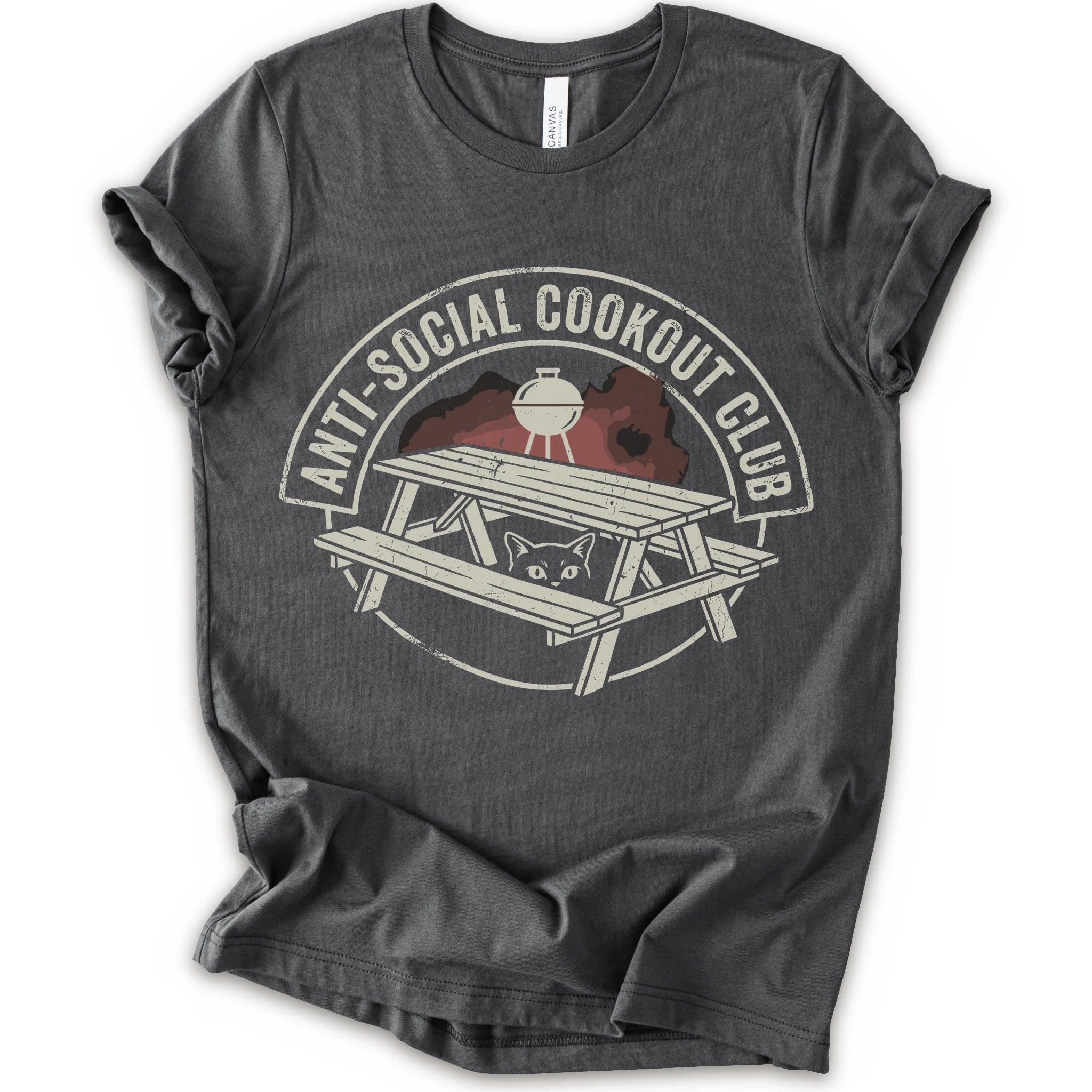 A asphalt short-sleeve crewneck t-shirt with a distressed graphic on the front. The graphic features a picnic table, a grill, and a cat peeking out from underneath, enclosed in a circle with the text 'ANTI-SOCIAL COOKOUT CLUB'.