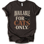 A brown short-sleeve t-shirt with a distressed graphic that reads 'AVAILABLE FOR CATS ONLY.' in beige and brown-orange lettering, featuring a black cat illustration.