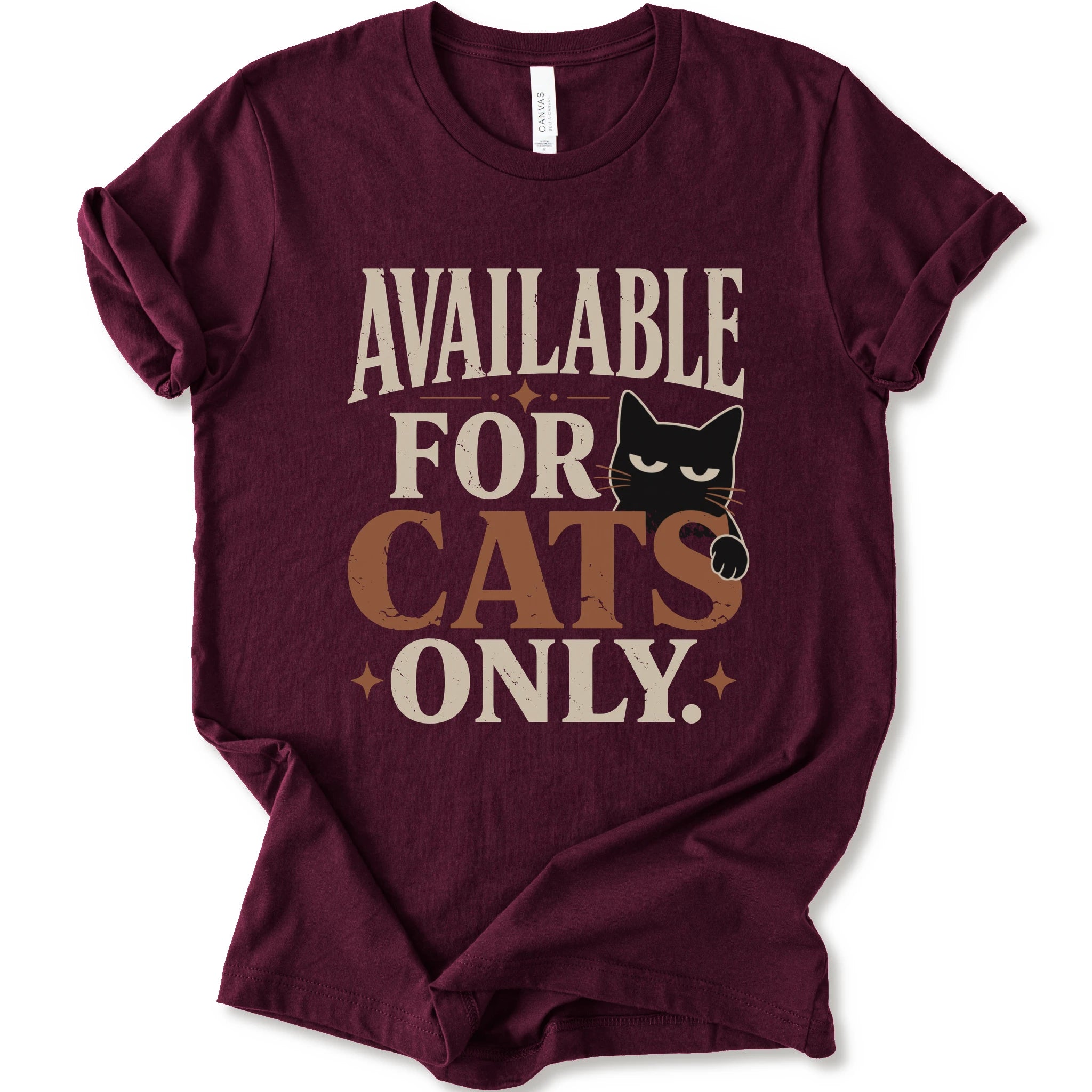 A maroon short-sleeve t-shirt with a distressed graphic that reads 'AVAILABLE FOR CATS ONLY.' in beige and brown-orange lettering, featuring a black cat illustration.