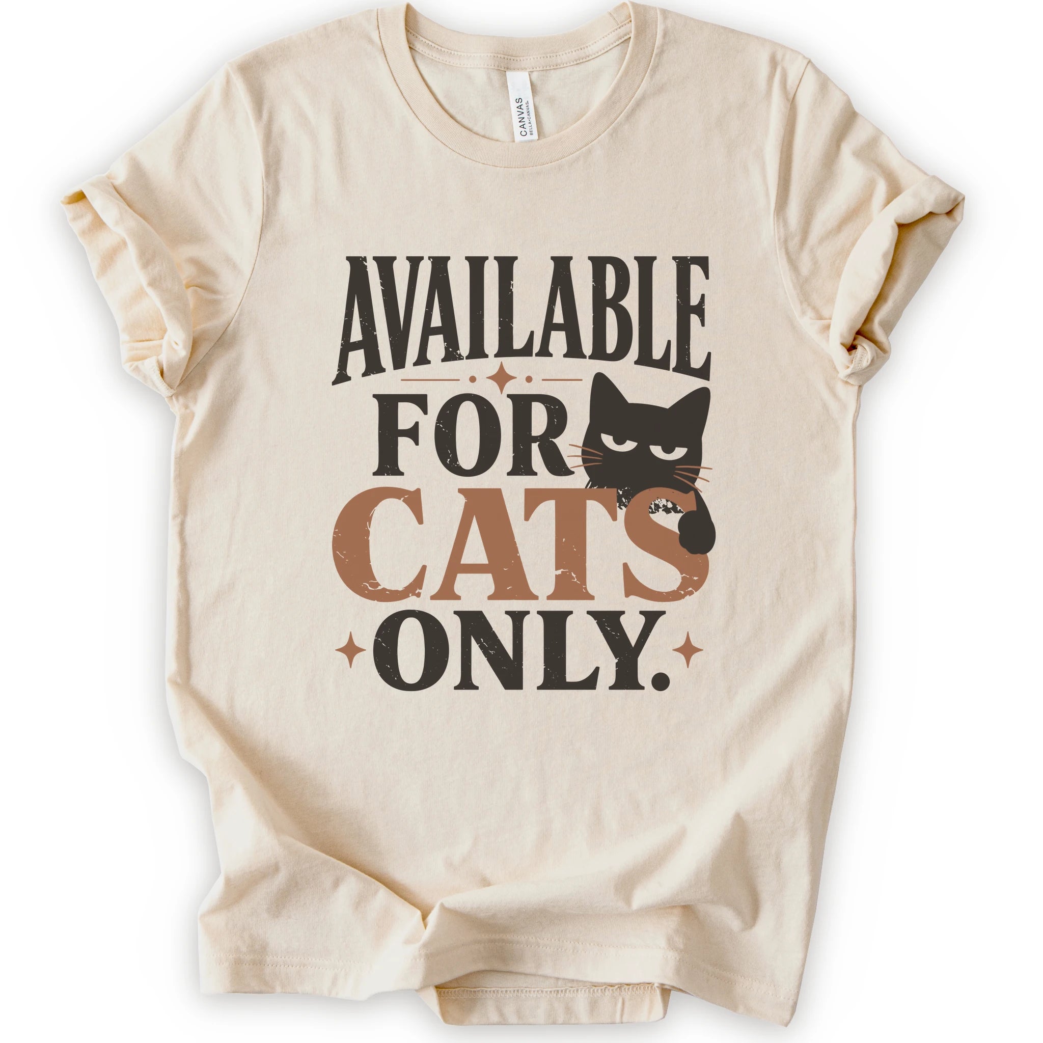 A natural short-sleeve t-shirt with a distressed graphic that reads 'AVAILABLE FOR CATS ONLY.' in brown and orange lettering, featuring a brown cat illustration.