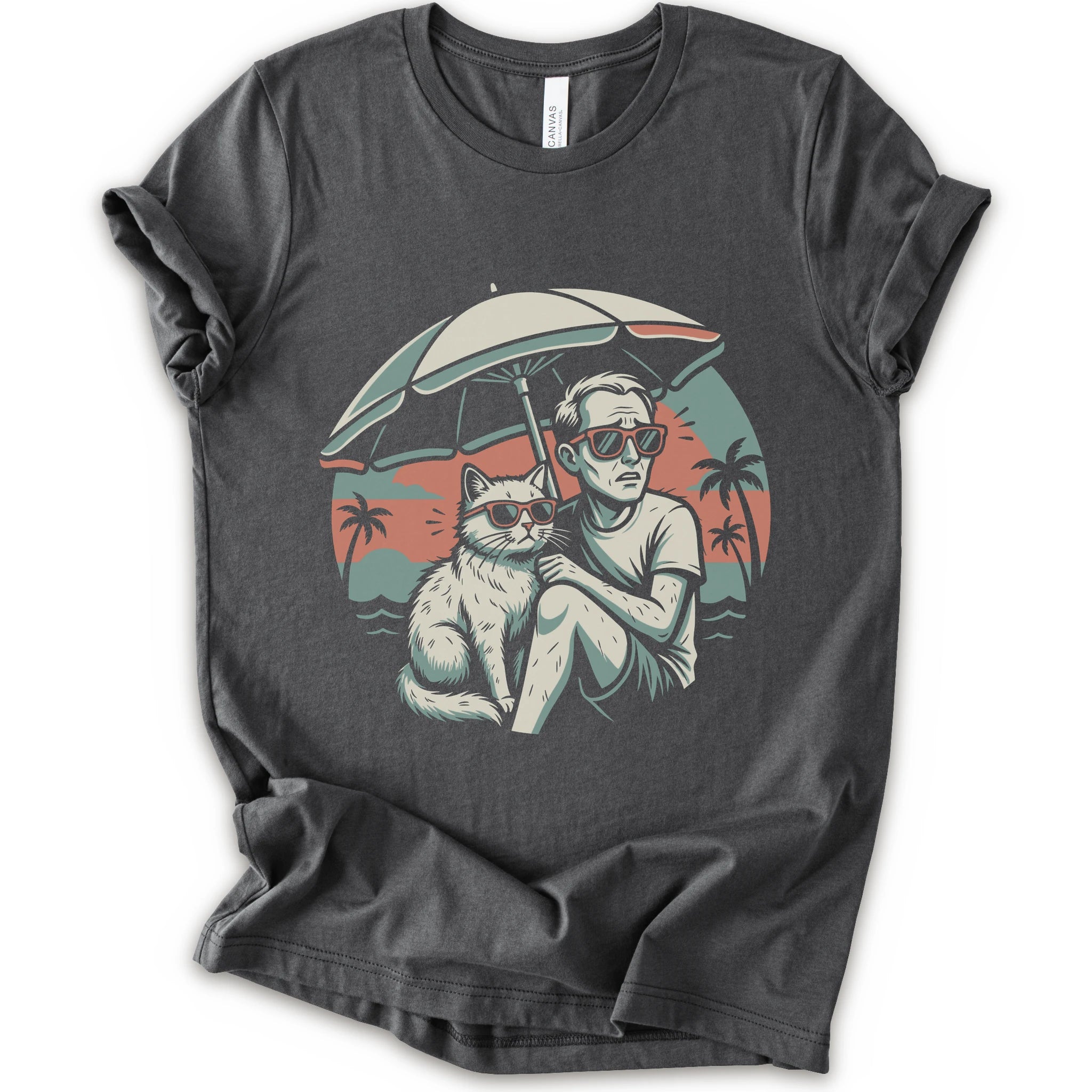 A asphalt short-sleeve crewneck t-shirt with a vintage-style graphic print of a man and a cat sitting under a beach umbrella on a sunset beach.