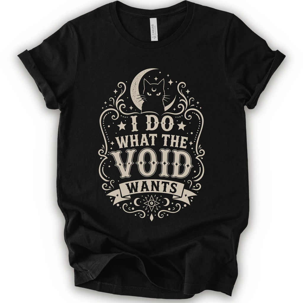 Black graphic t-shirt with a vintage-style cream graphic on the front. The graphic features a crescent moon, cat silhouette, stars, and the text 'I DO WHAT THE VOID WANTS'.
