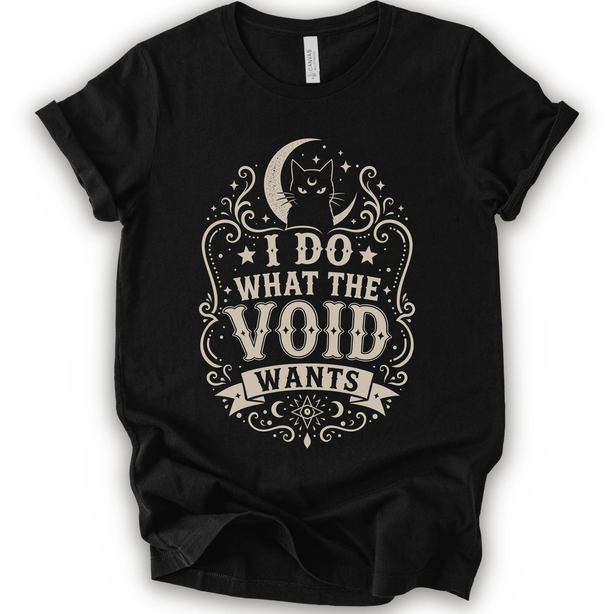 Black graphic t-shirt with a vintage-style cream graphic on the front. The graphic features a crescent moon, cat silhouette, stars, and the text 'I DO WHAT THE VOID WANTS'.