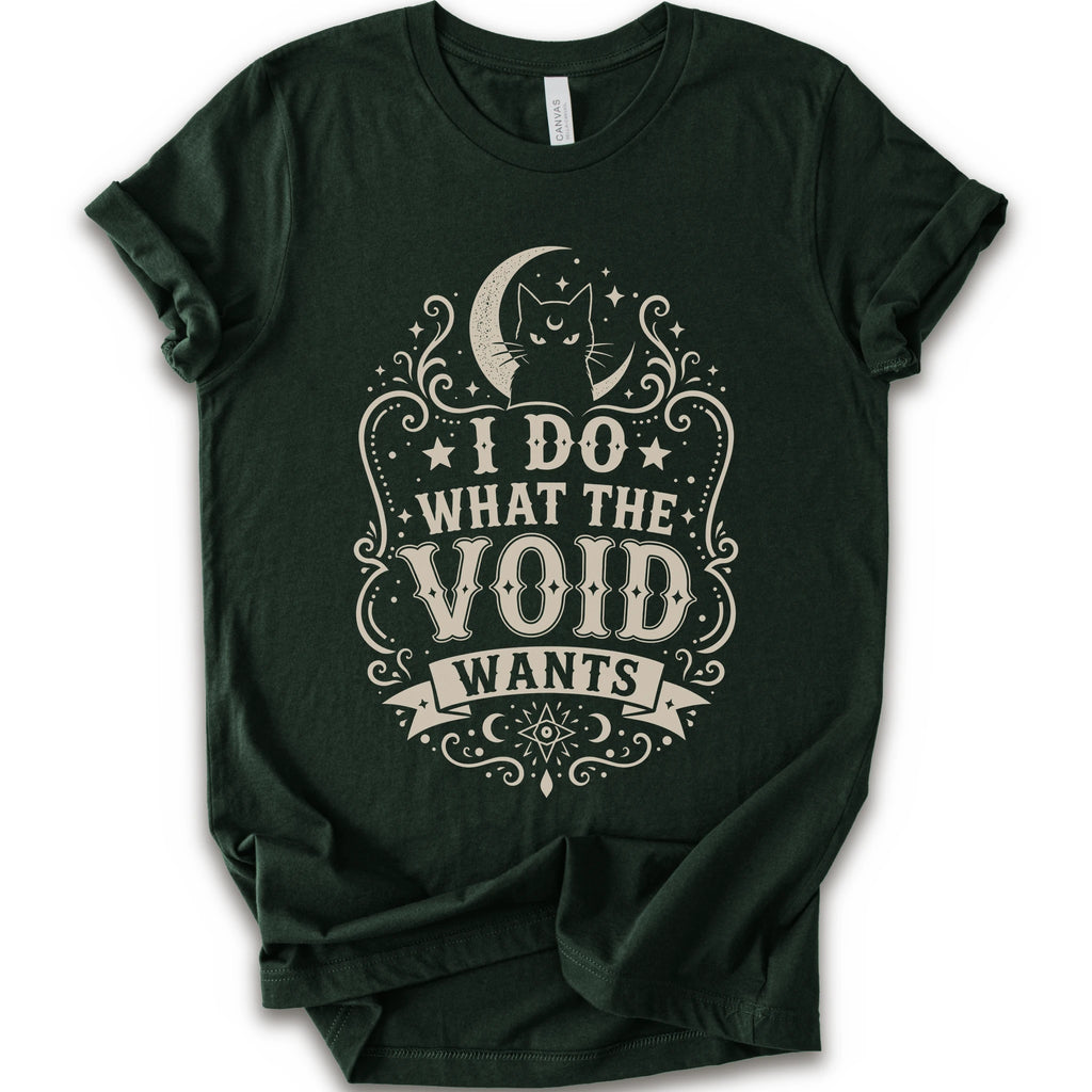 Forest graphic t-shirt with a vintage-style cream graphic on the front. The graphic features a crescent moon, cat silhouette, stars, and the text 'I DO WHAT THE VOID WANTS'.