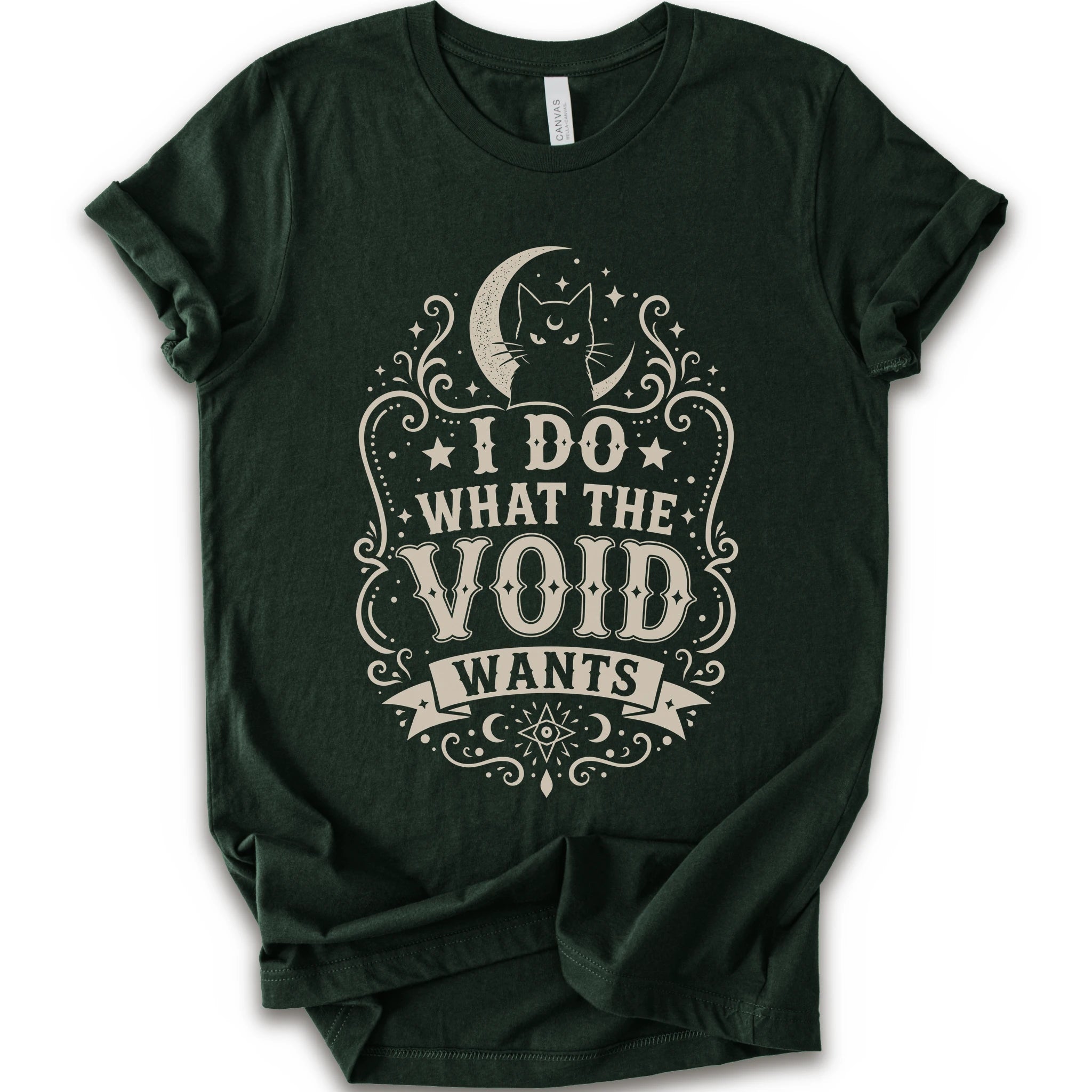 Forest graphic t-shirt with a vintage-style cream graphic on the front. The graphic features a crescent moon, cat silhouette, stars, and the text 'I DO WHAT THE VOID WANTS'.