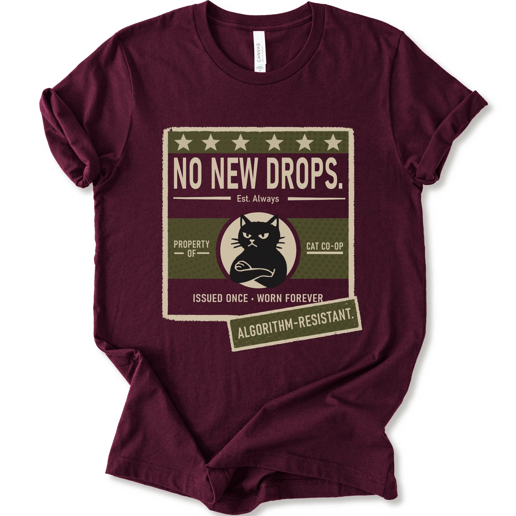 A maroon short-sleeve crewneck t-shirt with a vintage-style graphic print on the front. The graphic features a distressed beige and olive green box with the text 'NO NEW DROPS.