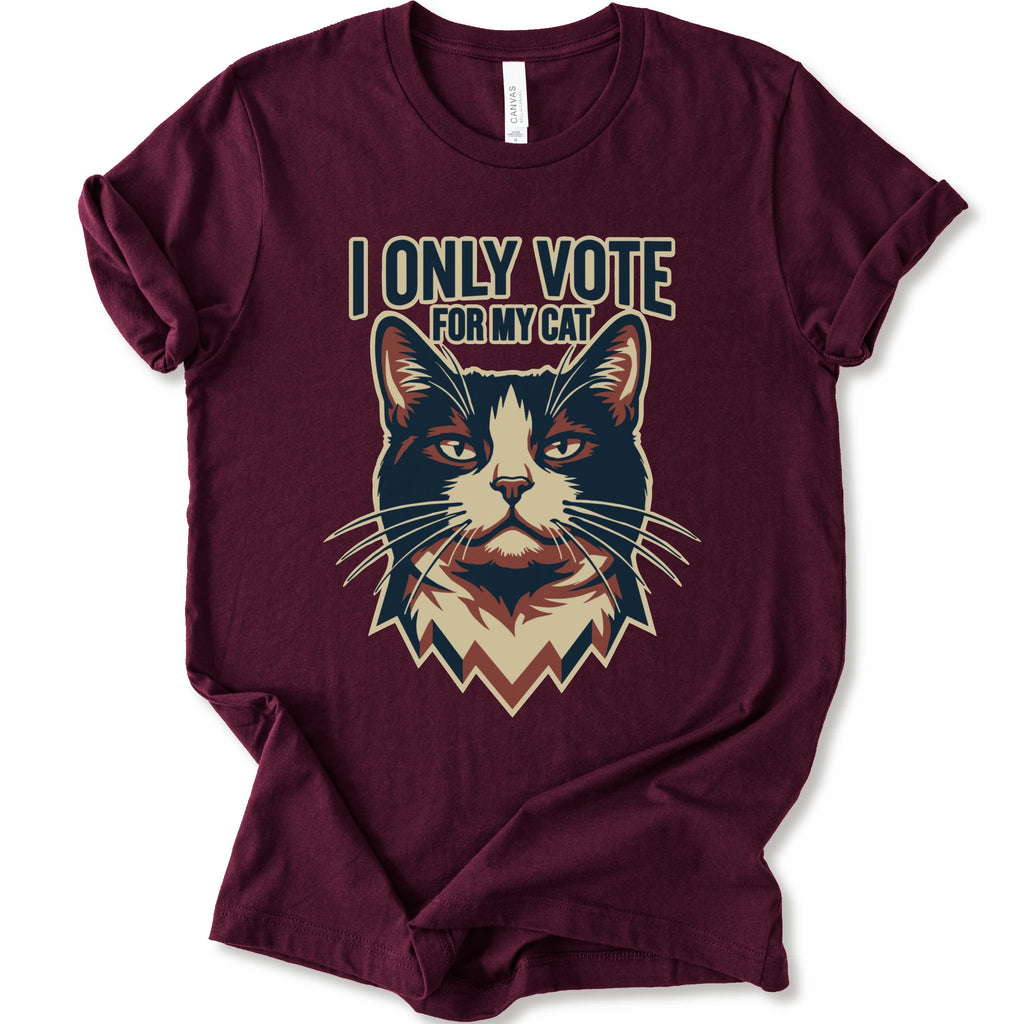 A maroon short-sleeve t-shirt with a graphic print of a cat's face and the text 'I ONLY VOTE FOR MY CAT' in a stylized font.