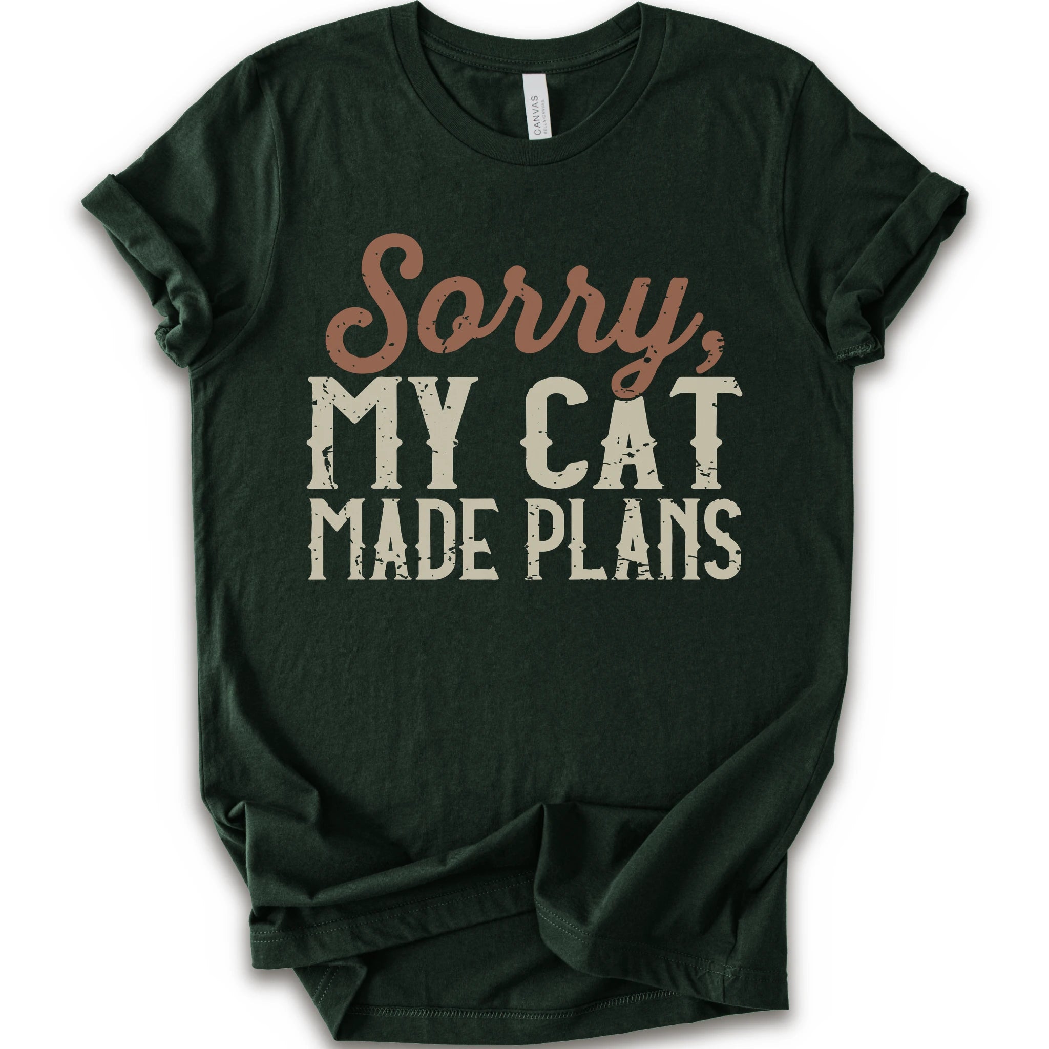 A forest short-sleeve crewneck t-shirt with a distressed graphic print that reads 'Sorry, MY CAT MADE PLANS' in brown and off-white lettering