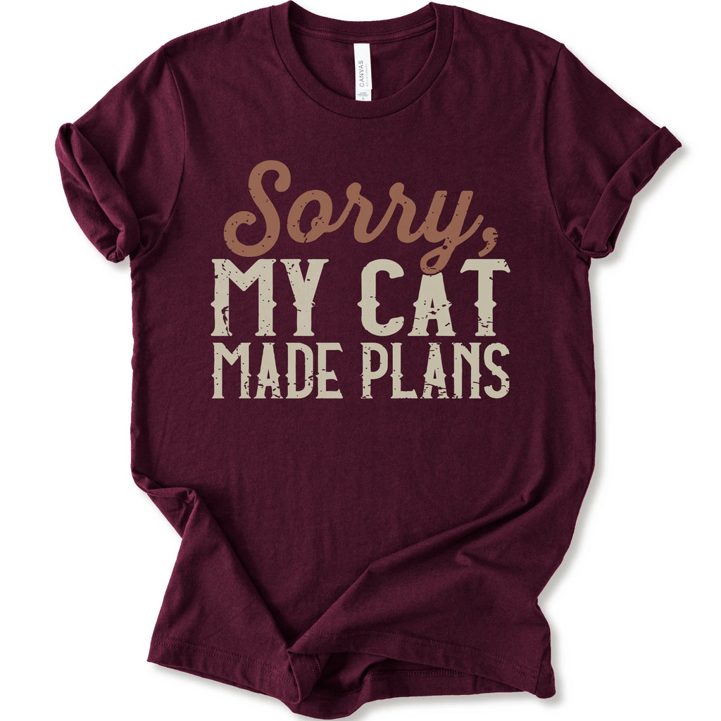 A maroon short-sleeve crewneck t-shirt with a distressed graphic print that reads 'Sorry, MY CAT MADE PLANS' in brown and off-white lettering