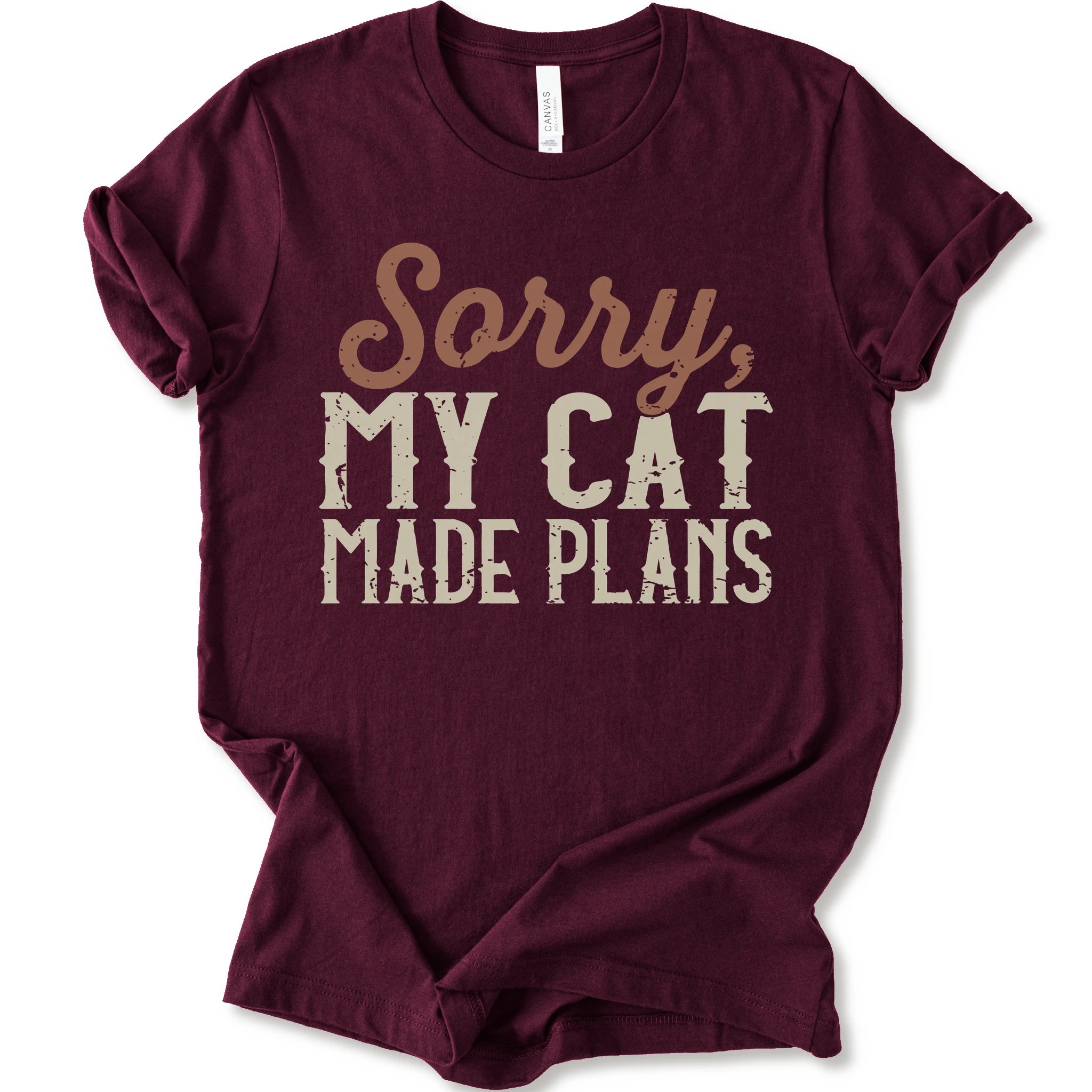 A maroon short-sleeve crewneck t-shirt with a distressed graphic print that reads 'Sorry, MY CAT MADE PLANS' in brown and off-white lettering