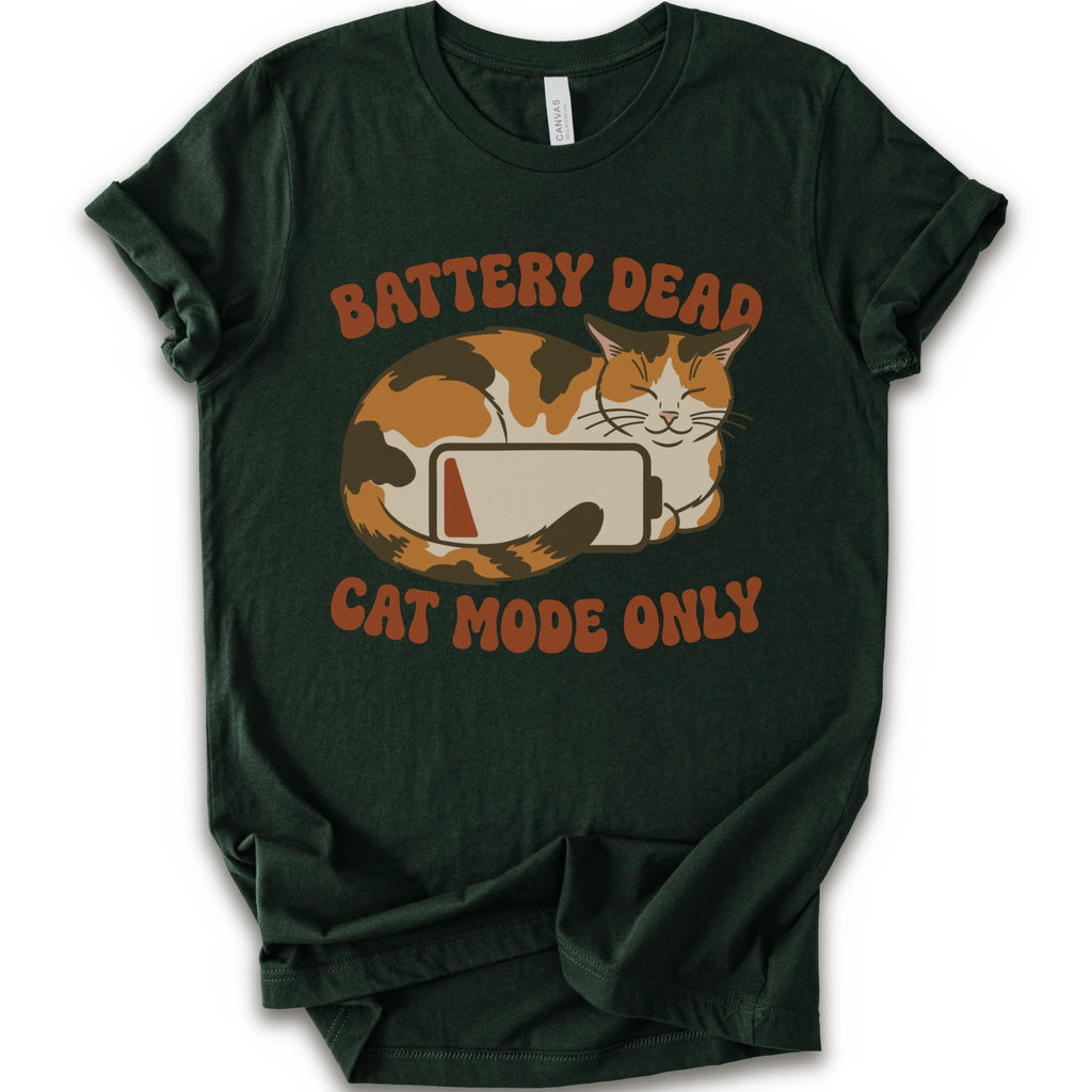 A forest short-sleeve graphic t-shirt featuring a cartoon calico cat curled up around a battery icon, with the text 'BATTERY DEAD CAT MODE ONLY' in orange-brown lettering.