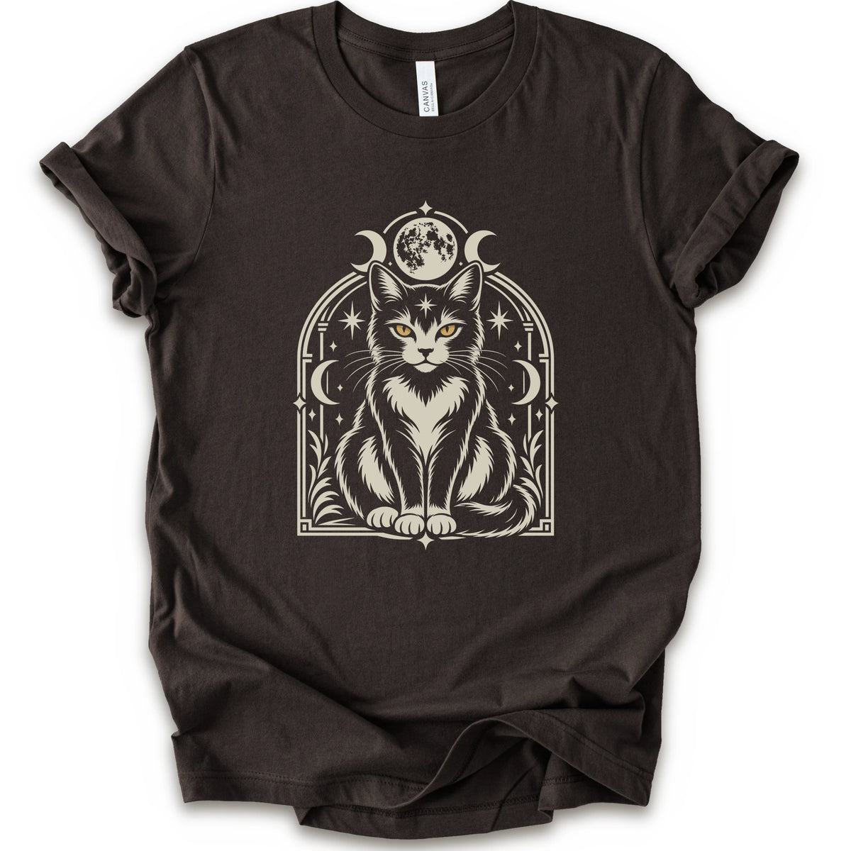 A brown short-sleeve crewneck t-shirt featuring a detailed graphic of a black and white cat with yellow eyes, framed by crescent moons and stars.