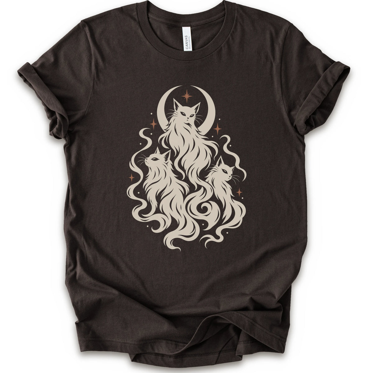 A brown short-sleeve crewneck t-shirt featuring a cream-colored graphic of three cats with long flowing hair in front of a crescent moon and stars.