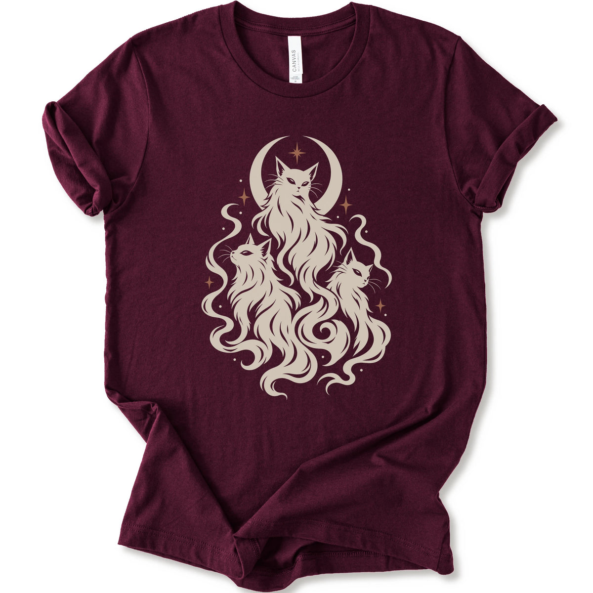 A maroon short-sleeve crewneck t-shirt featuring a cream-colored graphic of three cats with long flowing hair in front of a crescent moon and stars.