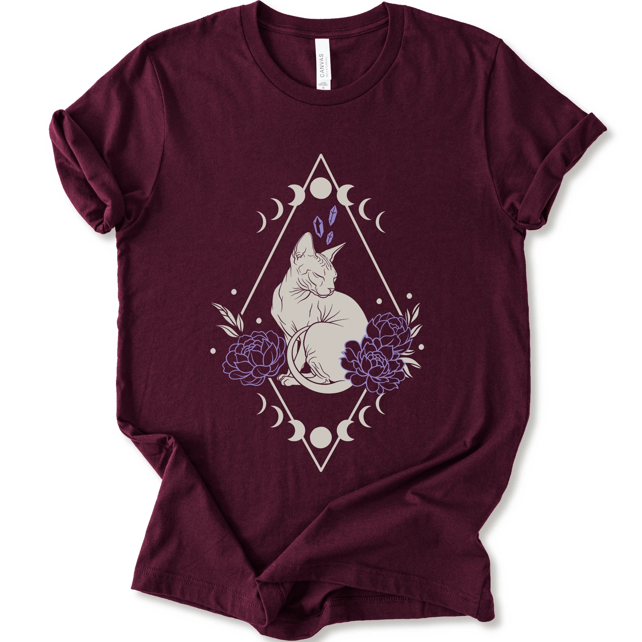 Maroon graphic t-shirt with white Sphynx cat with lavender flowers, crystals, moon phases and a geometric celestial frame