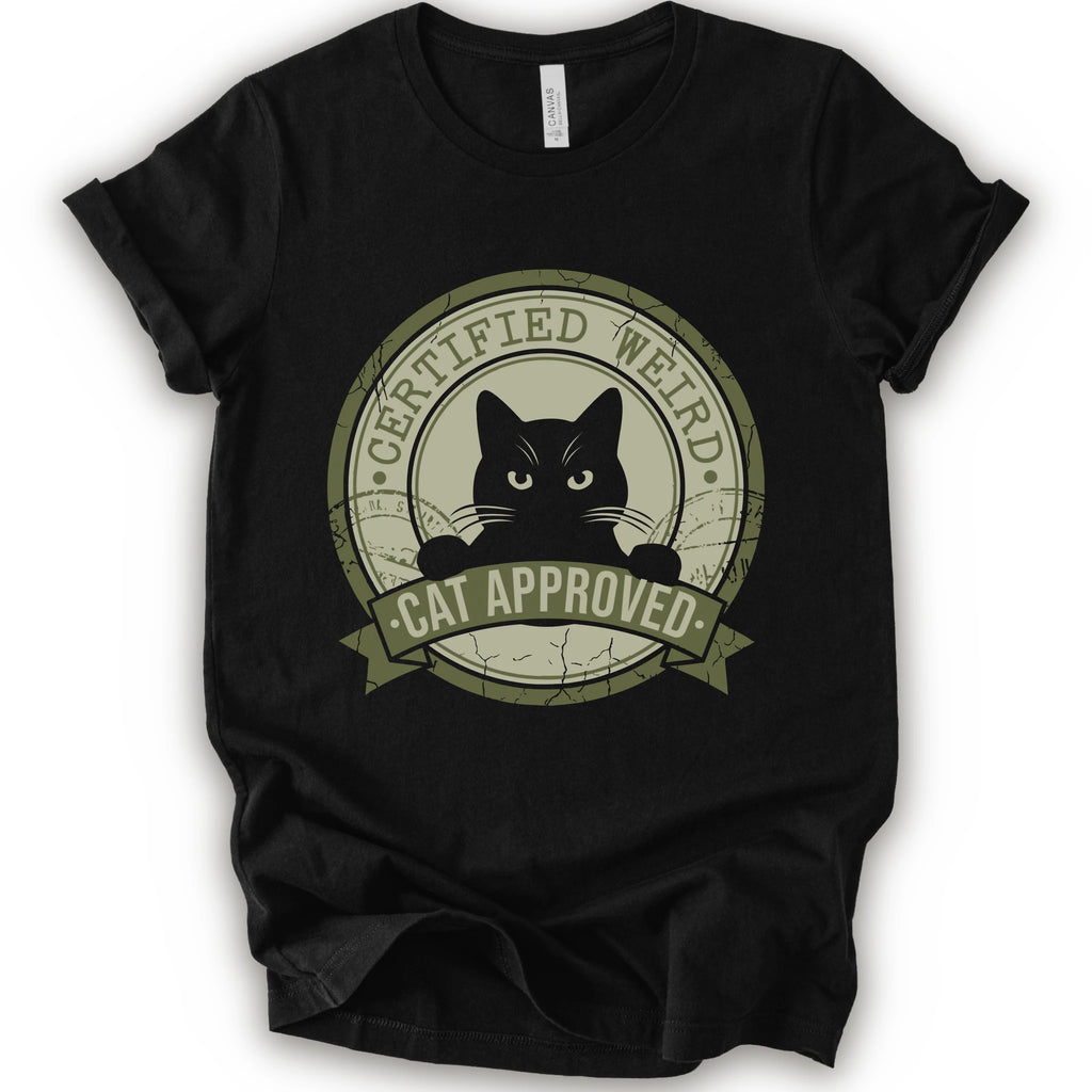 A black short-sleeve crewneck t-shirt with a vintage-style circular graphic on the front. The graphic features a black cat peeking out from inside a distressed olive green circle with a banner reading 'CERTIFIED WEIRD - CAT APPROVED'.
