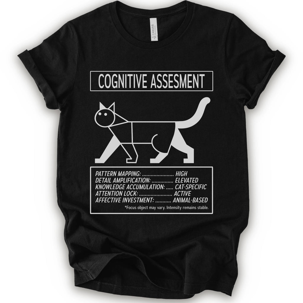 A black short-sleeve t-shirt with a white graphic print titled 'COGNITIVE ASSESSMENT' featuring a minimalist line drawing of a cat and a checklist-style design.