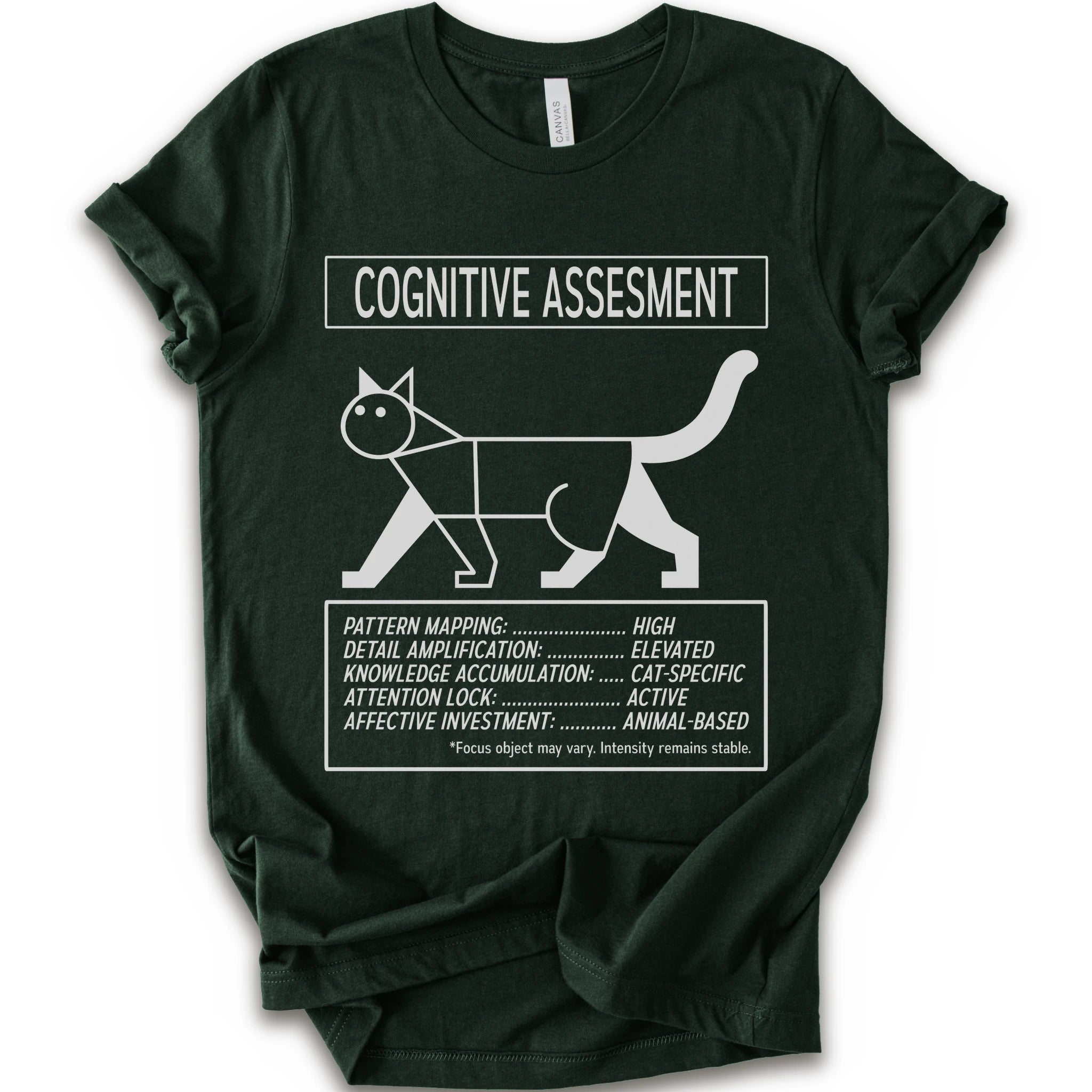 A forest short-sleeve t-shirt with a white graphic print titled 'COGNITIVE ASSESSMENT' featuring a minimalist line drawing of a cat and a checklist-style design.