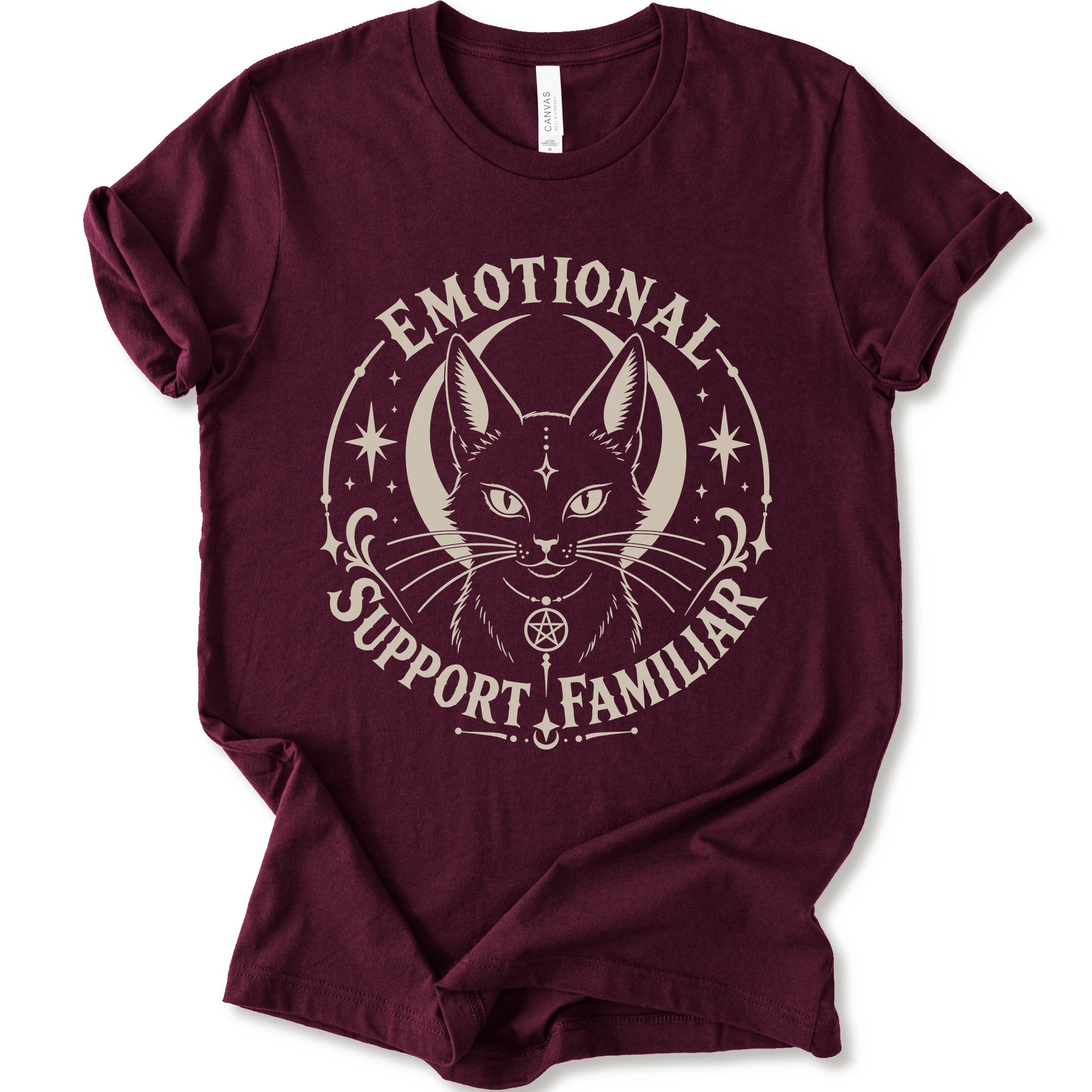 A maroon short-sleeve crewneck t-shirt with a distressed cream graphic of a cat's face inside a circle, surrounded by the text 'EMOTIONAL SUPPORT FAMILIAR'.