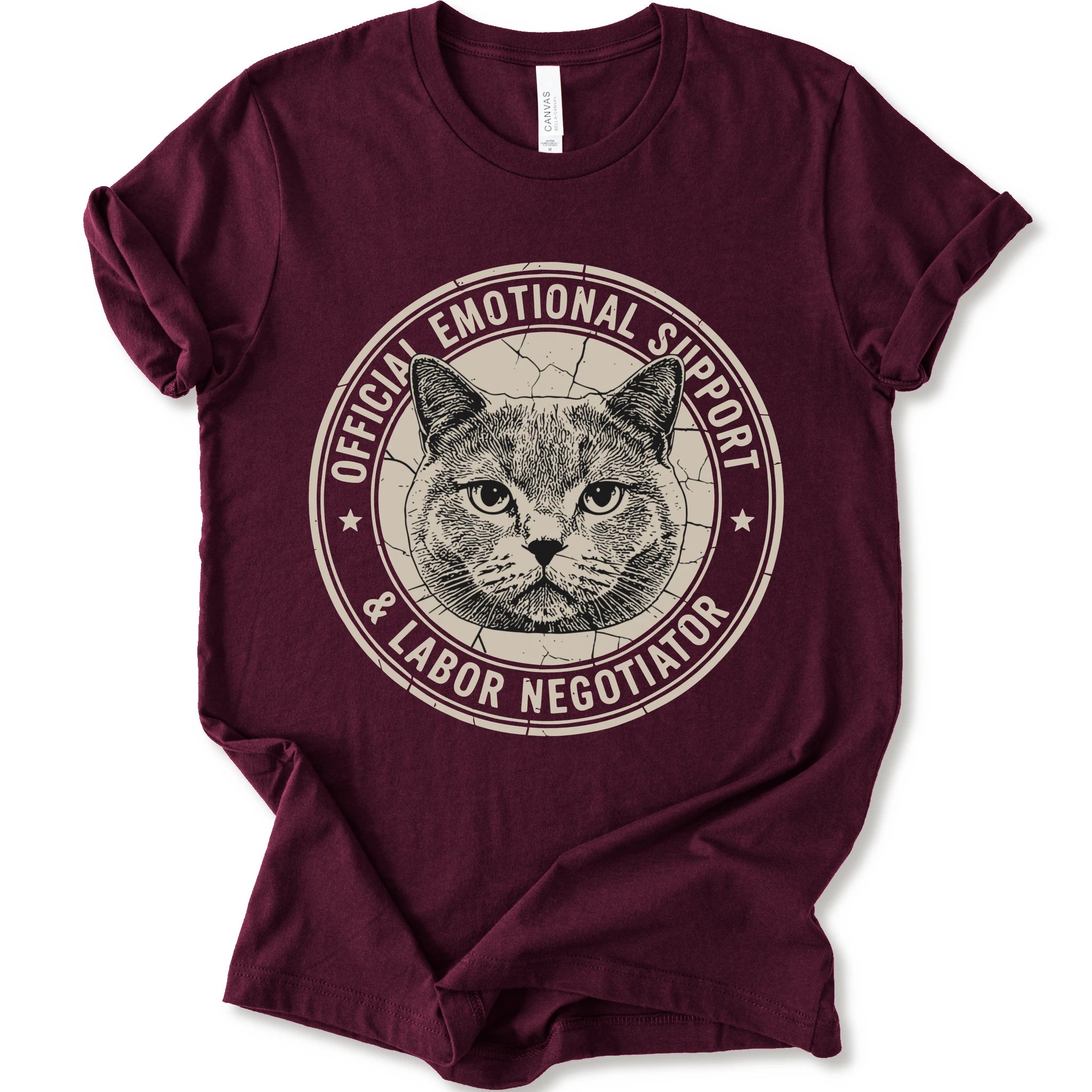 A maroon short-sleeve crewneck t-shirt with a distressed circular graphic on the chest featuring a cat's face and the text 'OFFICIAL EMOTIONAL SUPPORT & LABOR NEGOTIATOR'.