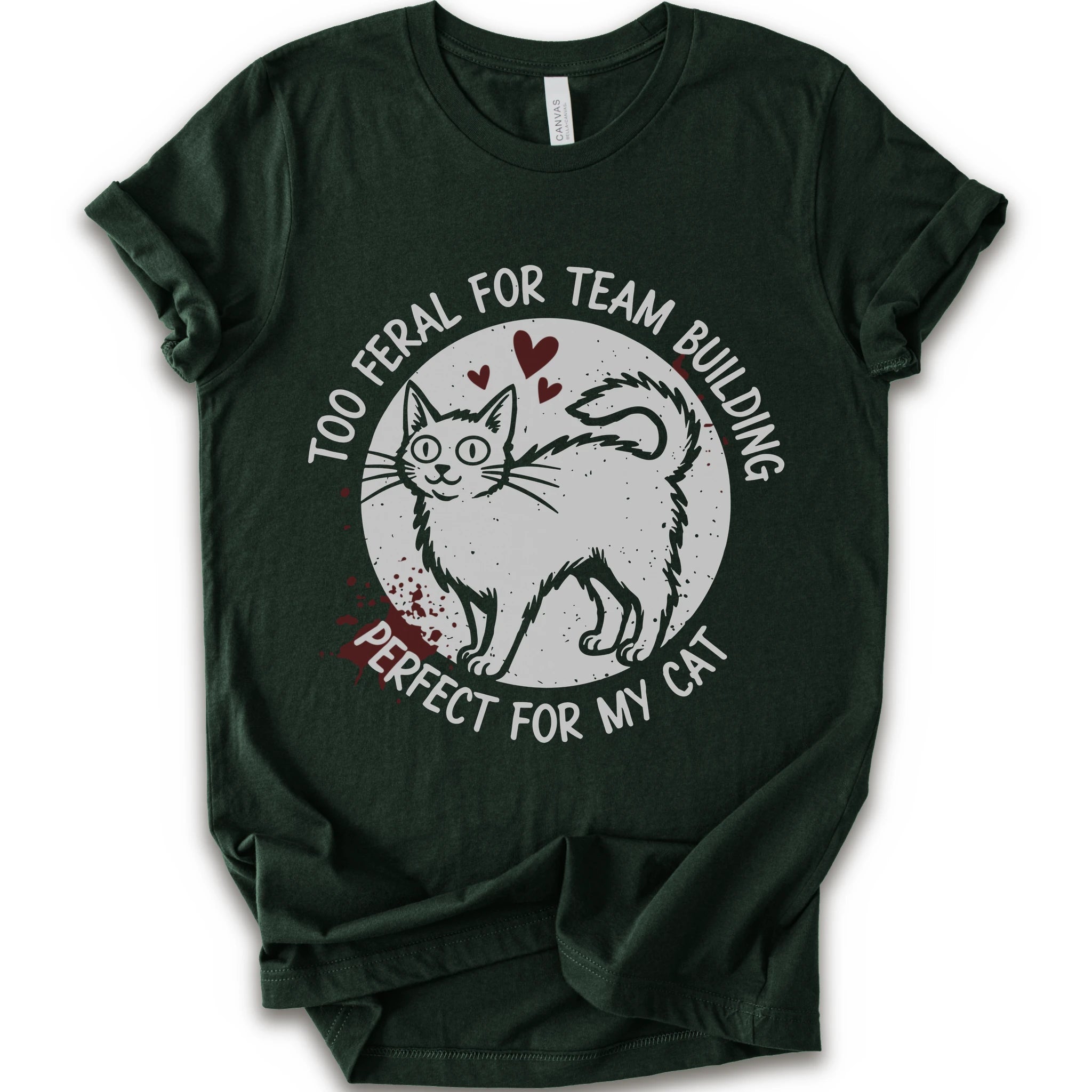 A forest short-sleeve crewneck t-shirt with a distressed white graphic of a cat inside a circle, surrounded by the text 'TOO FERAL FOR TEAM BUILDING' and 'PERFECT FOR MY CAT'.