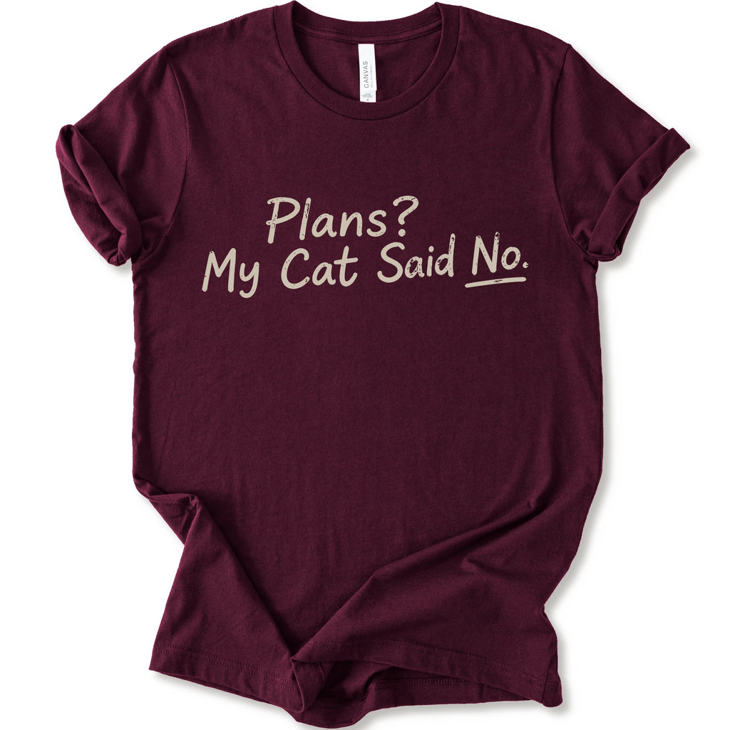 A maroon short-sleeve crewneck t-shirt with the phrase 'Plans? My Cat Said No.' printed in a beige handwritten font across the chest.