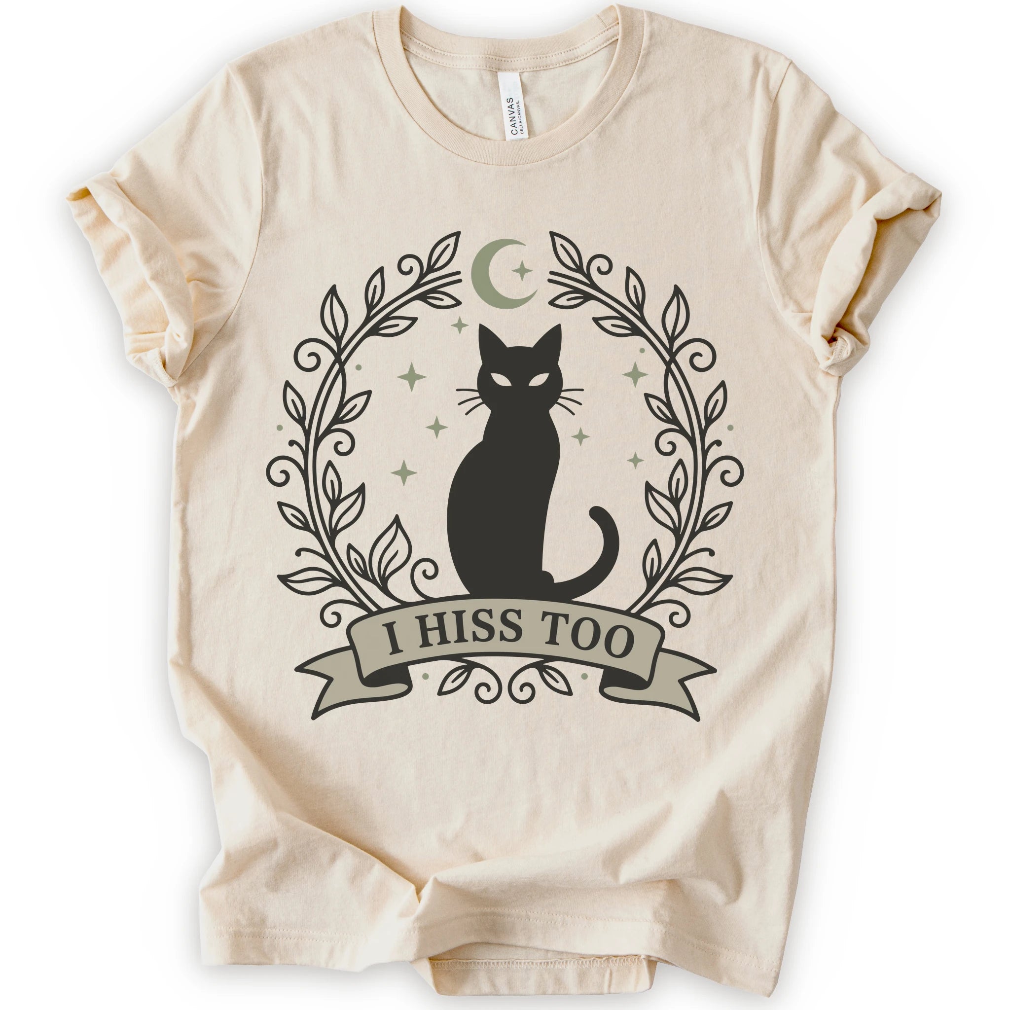 A Natural graphic t-shirt with black cat beneath a crescent moon and stars with leafy frame and “I HISS TOO” banner for a witchy T-shirt