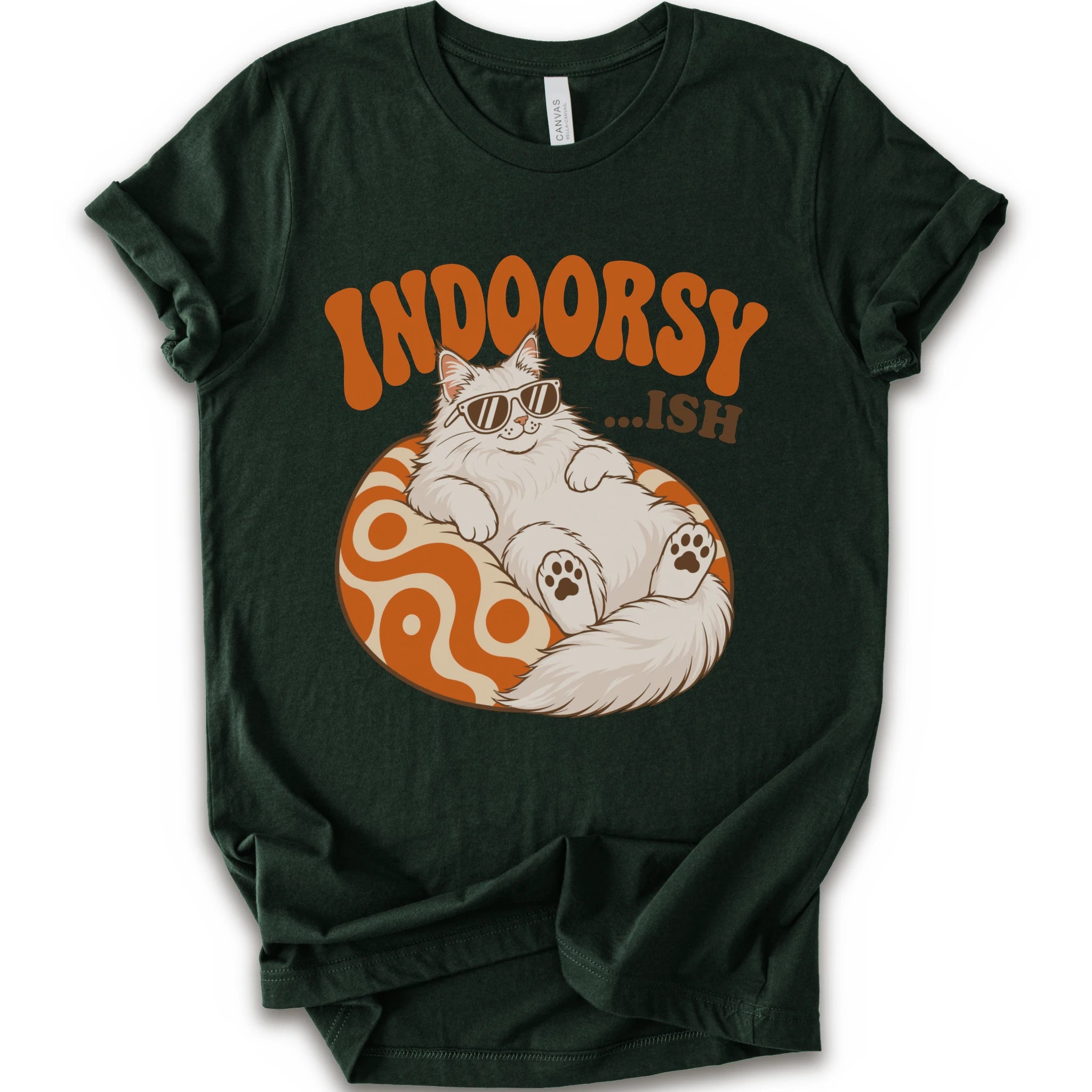 A forest short-sleeve crewneck t-shirt with a graphic print of a fluffy white Maine Coon cat wearing sunglasses, lounging on an orange and white swirl-patterned sphere. Above the cat, the text reads 'INDOORSY...ish".