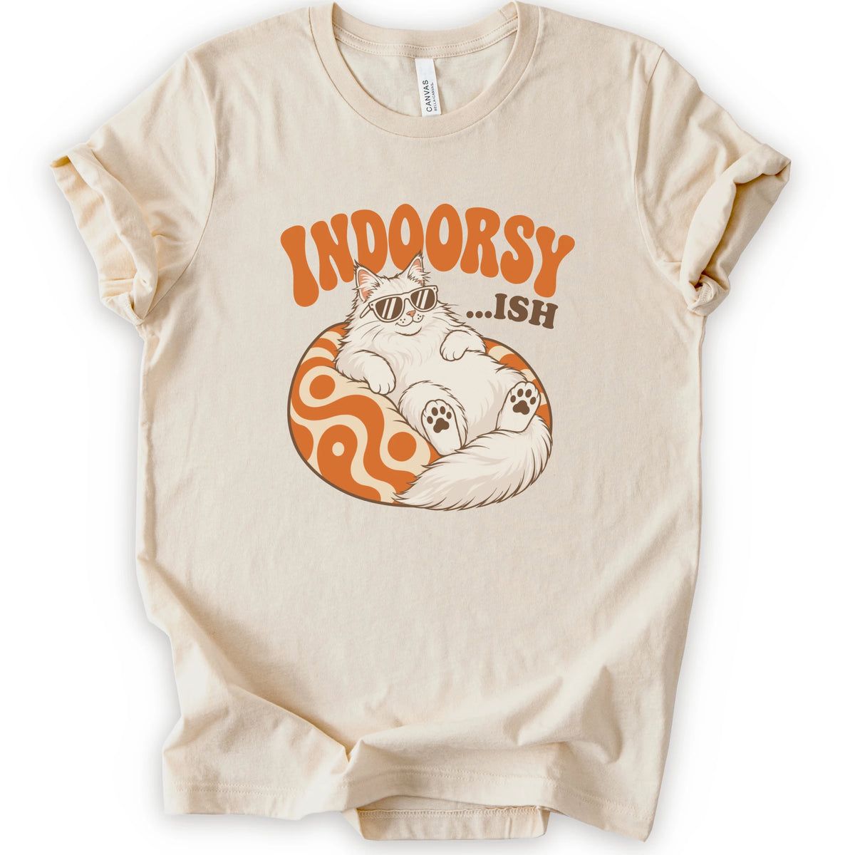 A natural short-sleeve t-shirt with a graphic of a white cat wearing sunglasses on an orange patterned ball, with the text 'INDOORSY... .ish'.