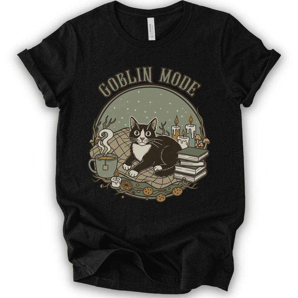 A black short-sleeve crewneck t-shirt with a cozy 'Goblin Mode' graphic print featuring a black and white cat, candles, books, and a mug.