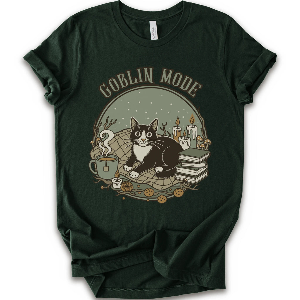 A forest short-sleeve crewneck t-shirt with a cozy 'Goblin Mode' graphic print featuring a black and white cat, candles, books, and a mug.