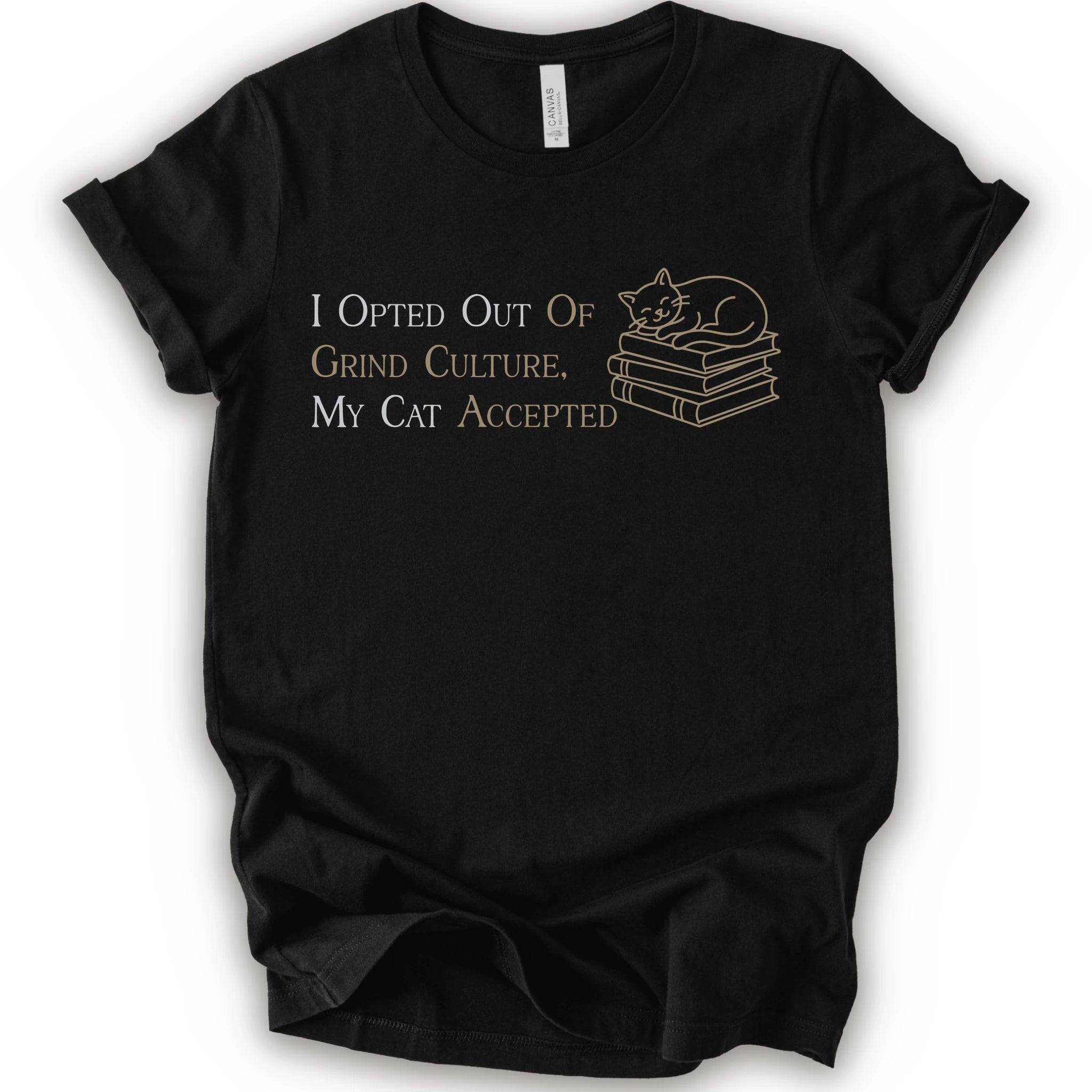 A black short-sleeve crew neck T-shirt with "I Opted Out Of Grind Culture, My Cat Accepted" lettering beside a sleeping cat on stacked books