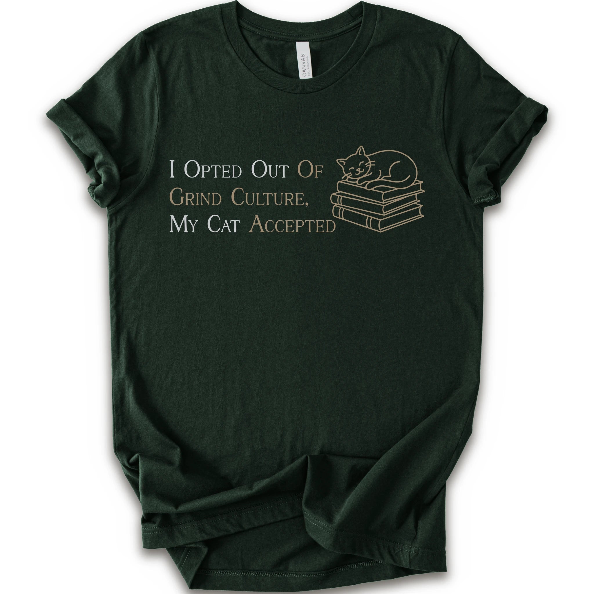 A forest short-sleeve crew neck T-shirt with "I Opted Out Of Grind Culture, My Cat Accepted" lettering beside a sleeping cat on stacked books