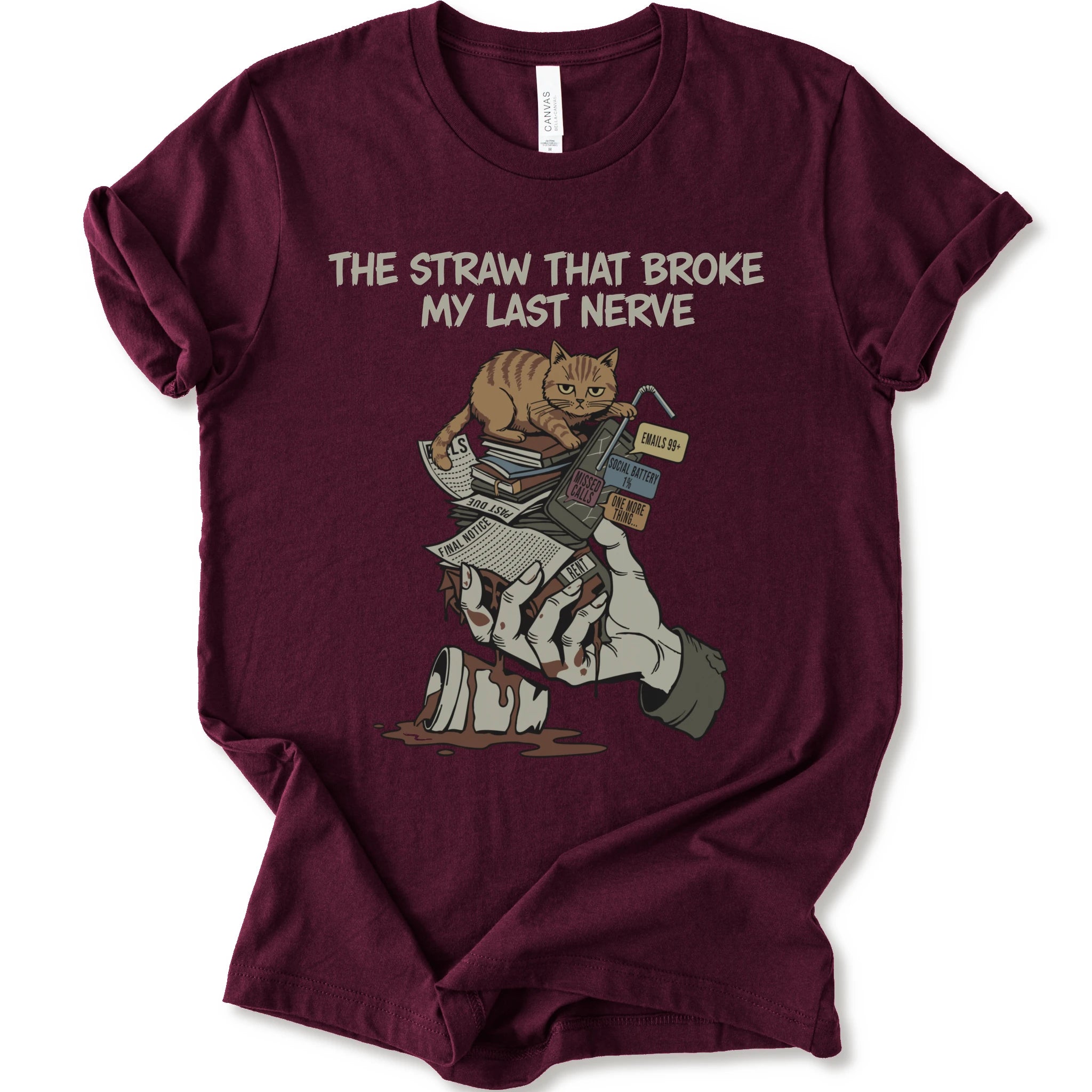 A maroon short-sleeve graphic t-shirt featuring a cartoon illustration of an orange tabby cat sitting on books and a bloody hand holding a broken straw, with the text 'THE STRAW THAT BROKE MY LAST NERVE' printed above.