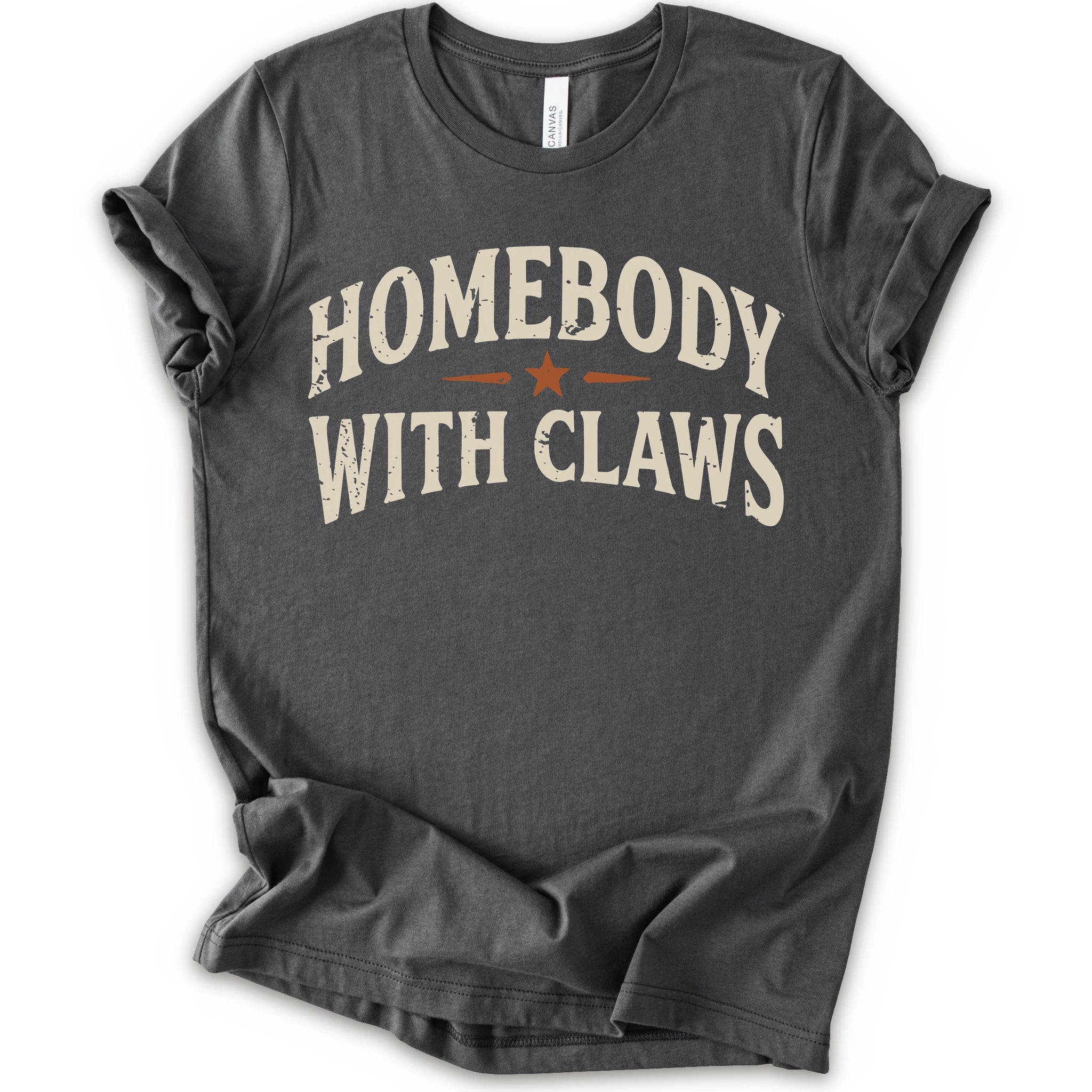 A asphalt short-sleeve t-shirt with a distressed graphic reading 'HOMEBODY WITH CLAWS' in cream lettering and a small orange star accent