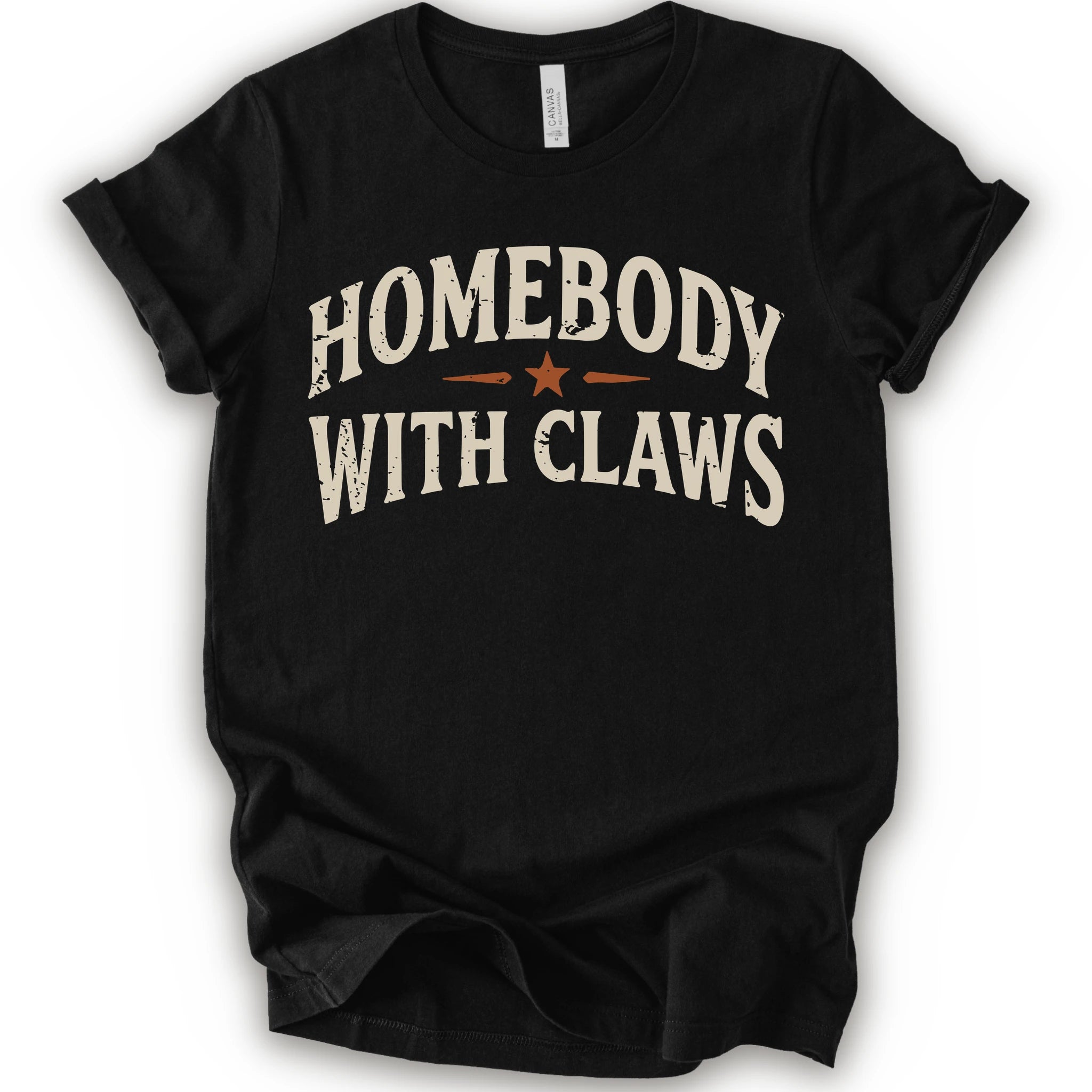 A black short-sleeve t-shirt with a distressed graphic reading 'HOMEBODY WITH CLAWS' in cream lettering and a small orange star accent
