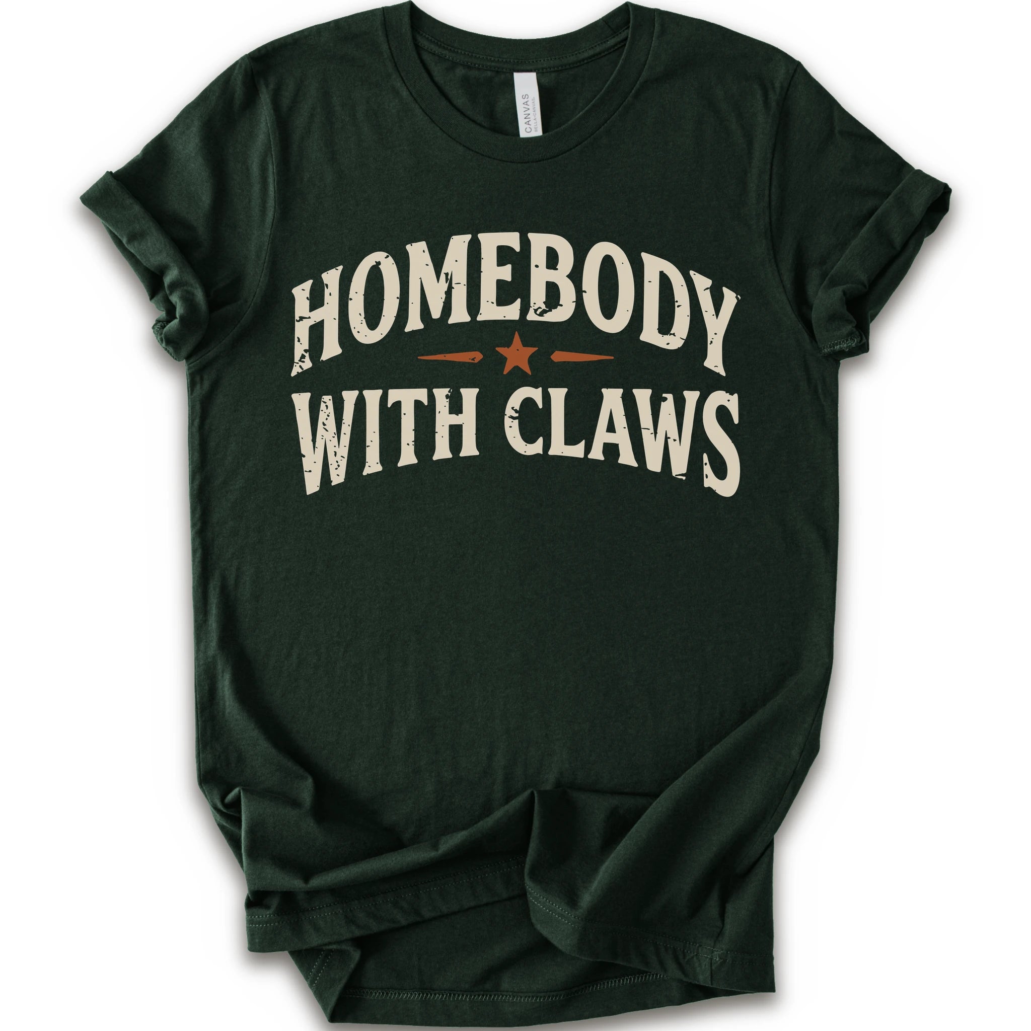 A forest short-sleeve t-shirt with a distressed graphic reading 'HOMEBODY WITH CLAWS' in cream lettering and a small orange star accent