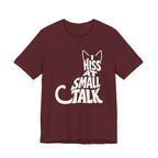 A maroon short-sleeve crewneck t-shirt featuring a graphic with Off-white “I Hiss at Small Talk” typography with pointed cat ears and a large curved tail