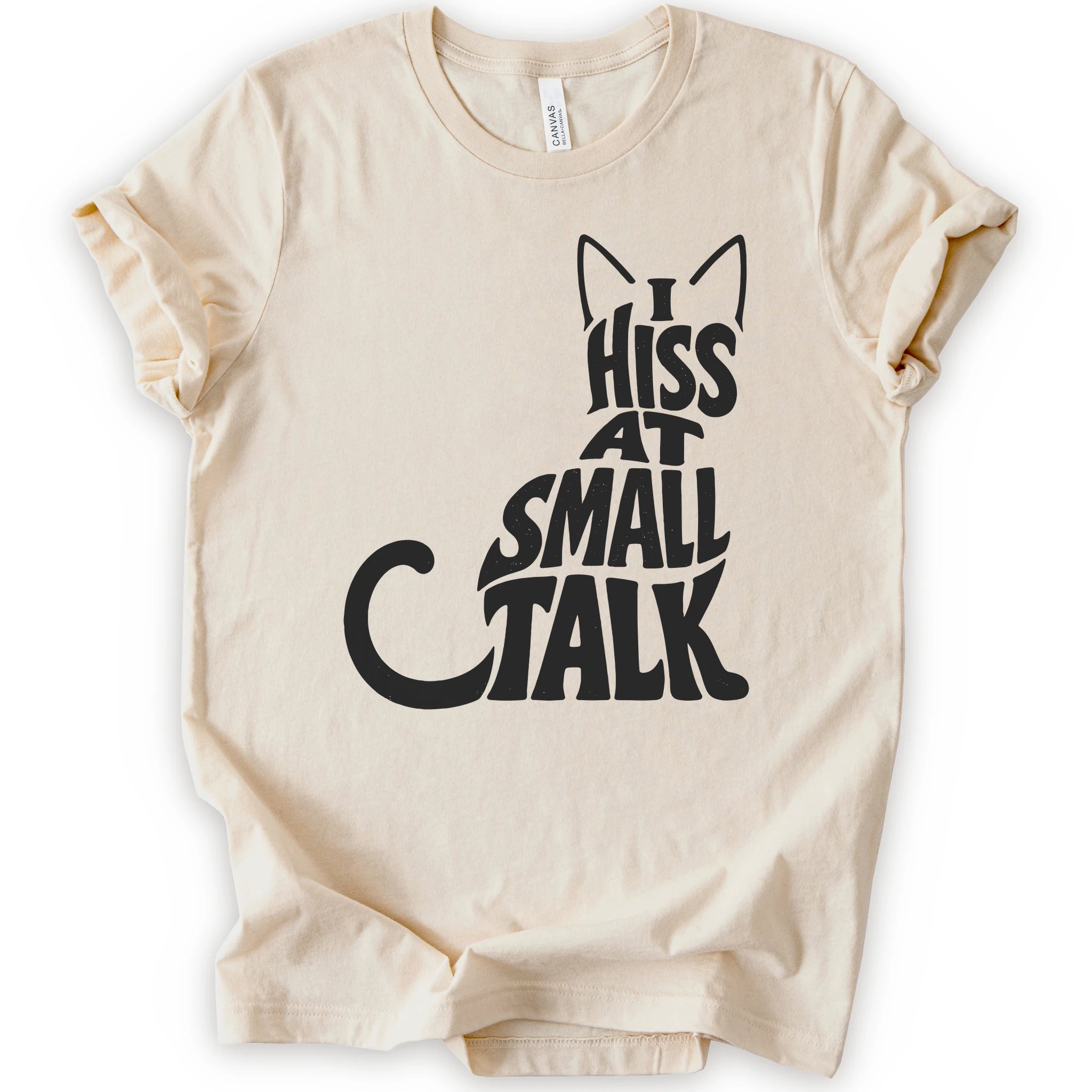 Natural graphic t-shirt with black “I Hiss at Small Talk” typography with pointed cat ears and a large curved tail