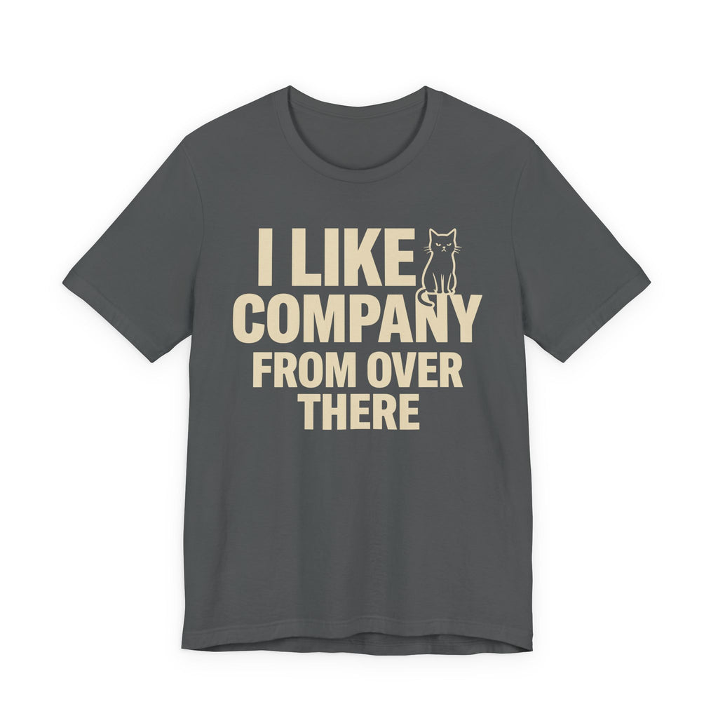 A asphalt short-sleeve t-shirt with a beige graphic print that reads "I Like Company From Over There" with an unimpressed sitting cat